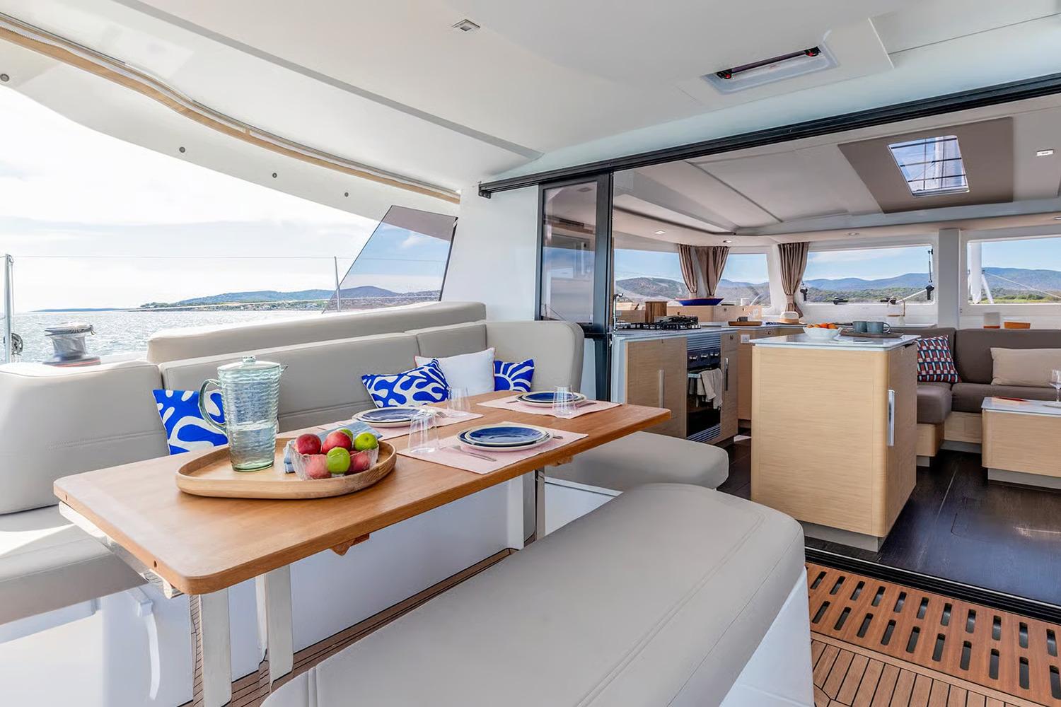Manufacturer Provided Image: Luxurious interior of 2026 Fountaine Pajot FP44 Catamaran with dining area and scenic ocean view.