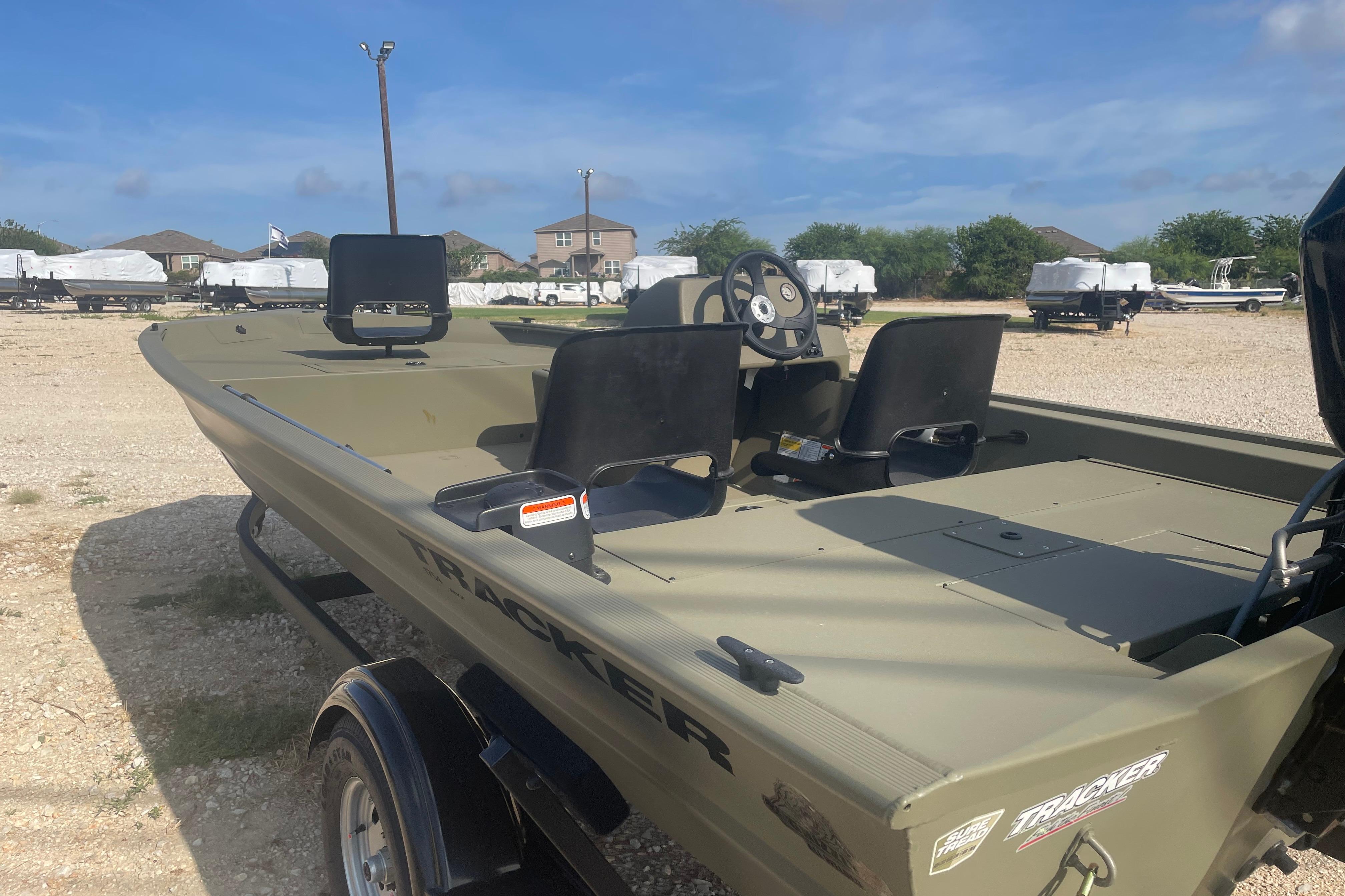 2026 Tracker Grizzly 1754 SC boat on trailer, parked outdoors under clear sky.