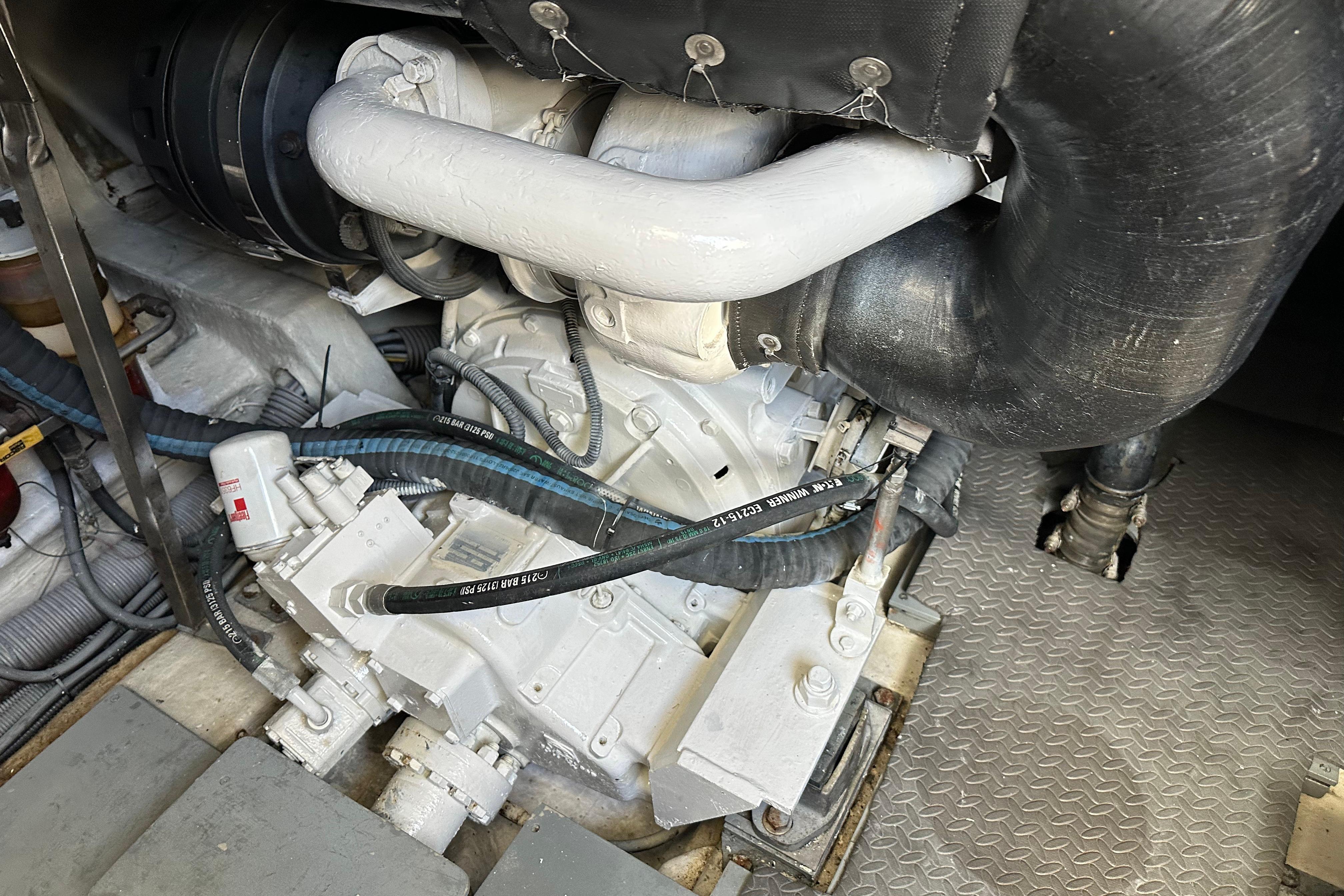 Engine compartment of a 2004 Azimut 55E yacht, showcasing mechanical components and hoses.