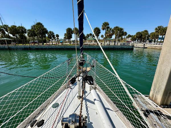 Bow of 1989 Concordia 52 sailboat docked in a marina with palm trees.