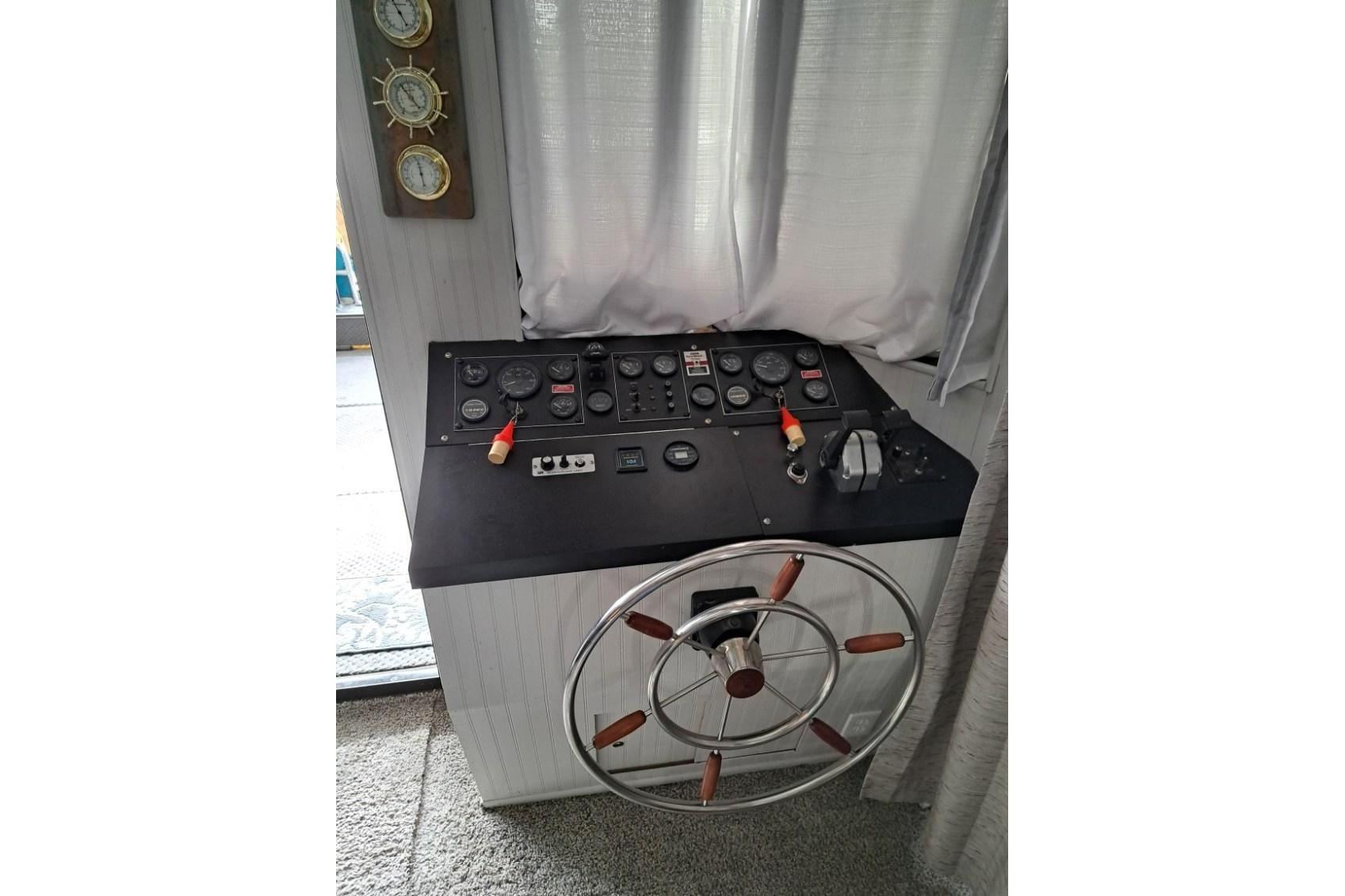 Control panel of a 1990 Sumerset 16 x 70 houseboat with steering wheel.