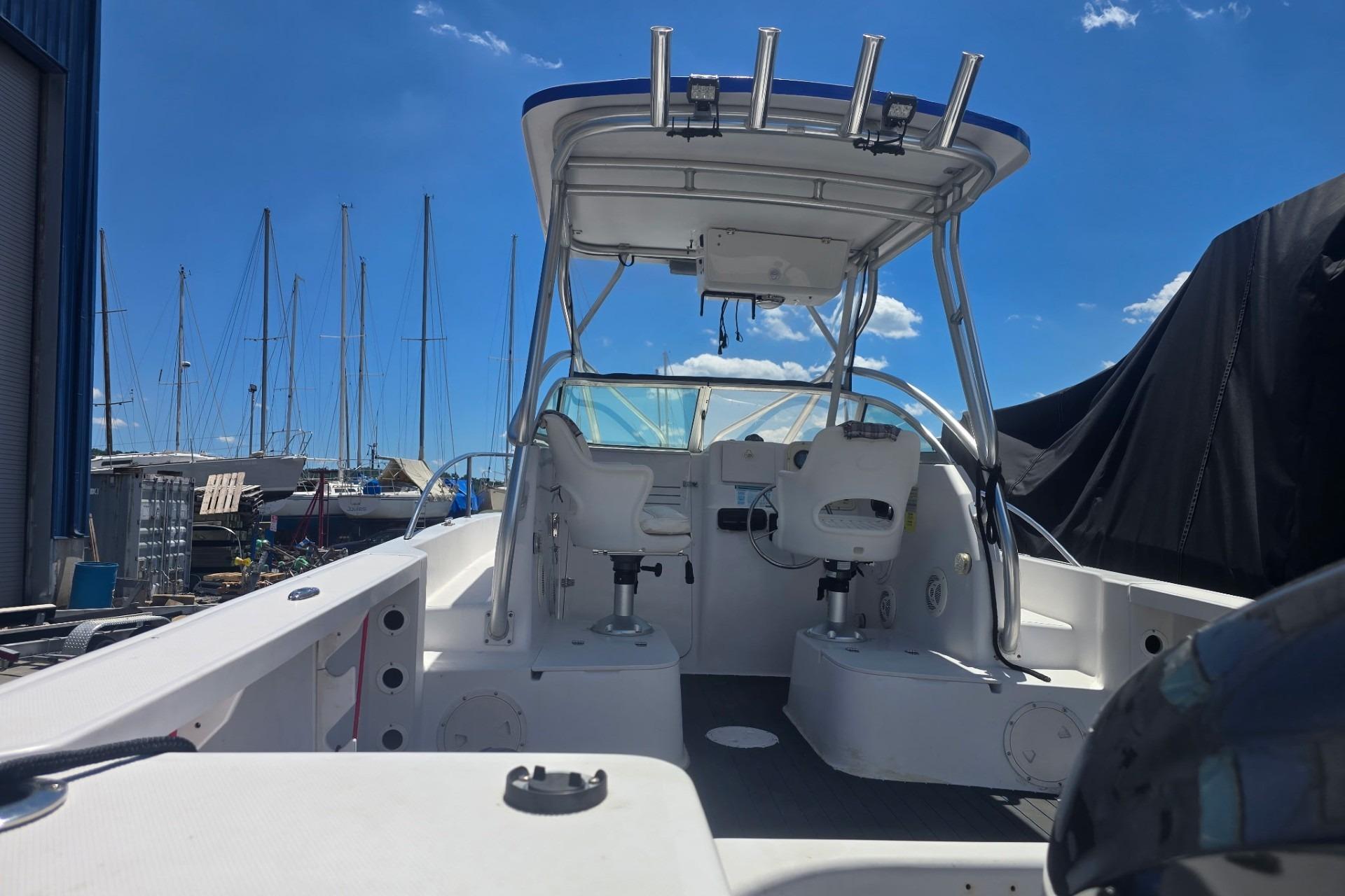 2003 Pro-Line 22 Walkaround boat interior with helm, seats, and clear blue sky background.