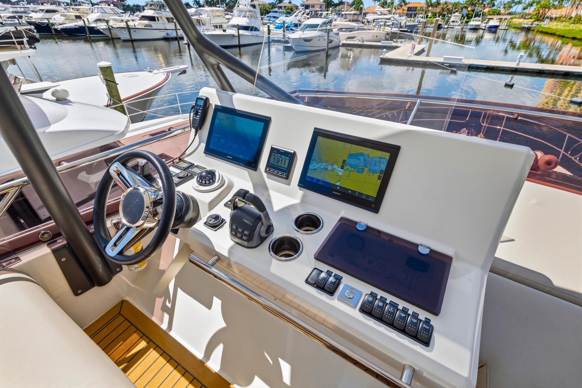 Cockpit of 2022 Prestige 520 yacht with navigation screens and controls at marina.
