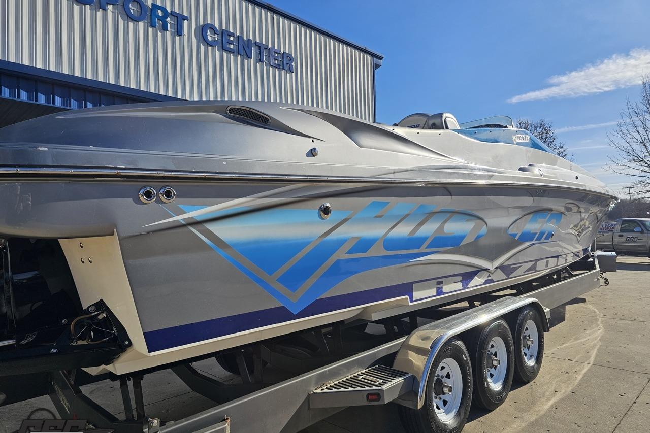 2007 Hustler 41 Razor boat on trailer outside a sport center.