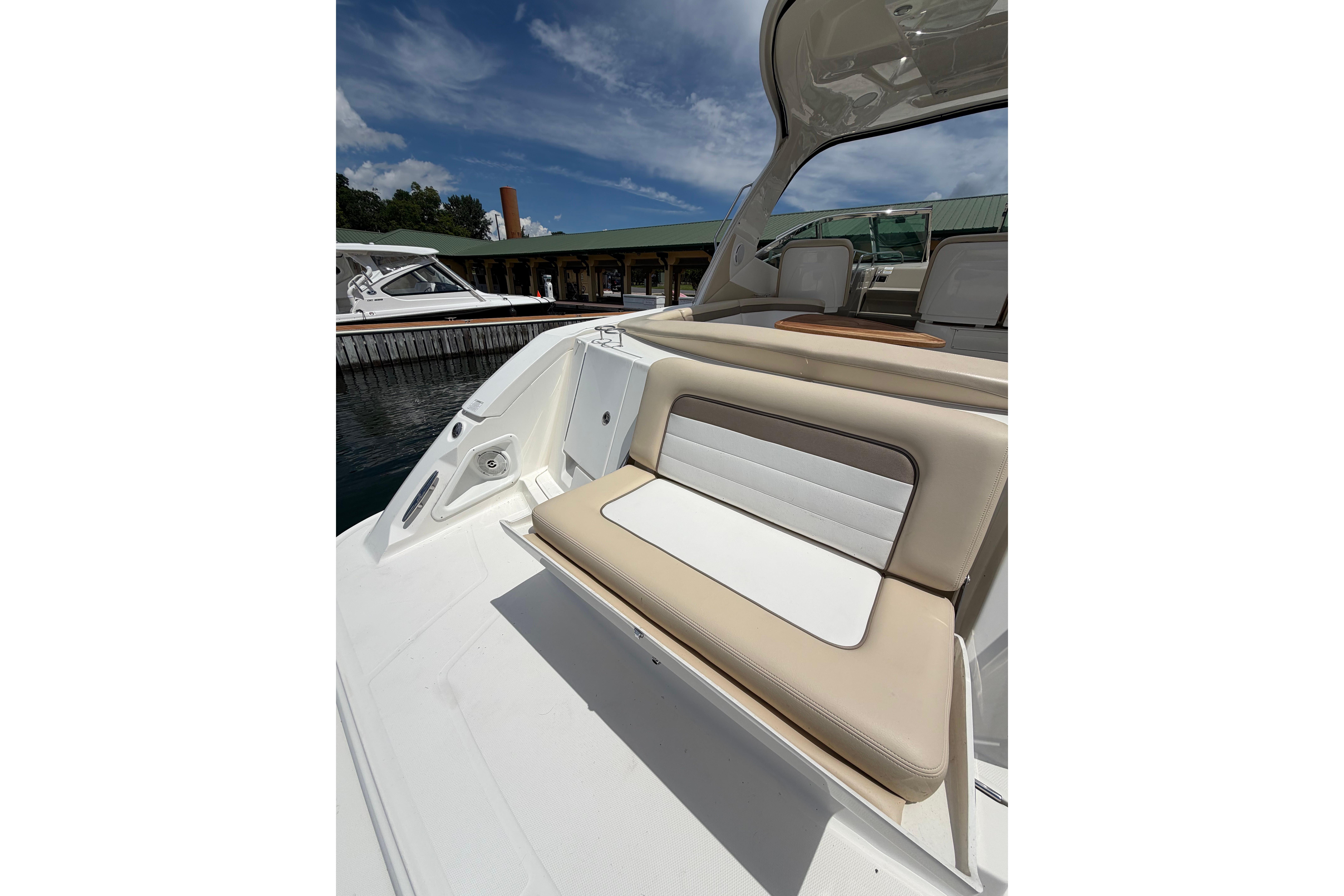 2012 Sea Ray Sundancer 370 boat interior with cushioned seating under a clear sky.
