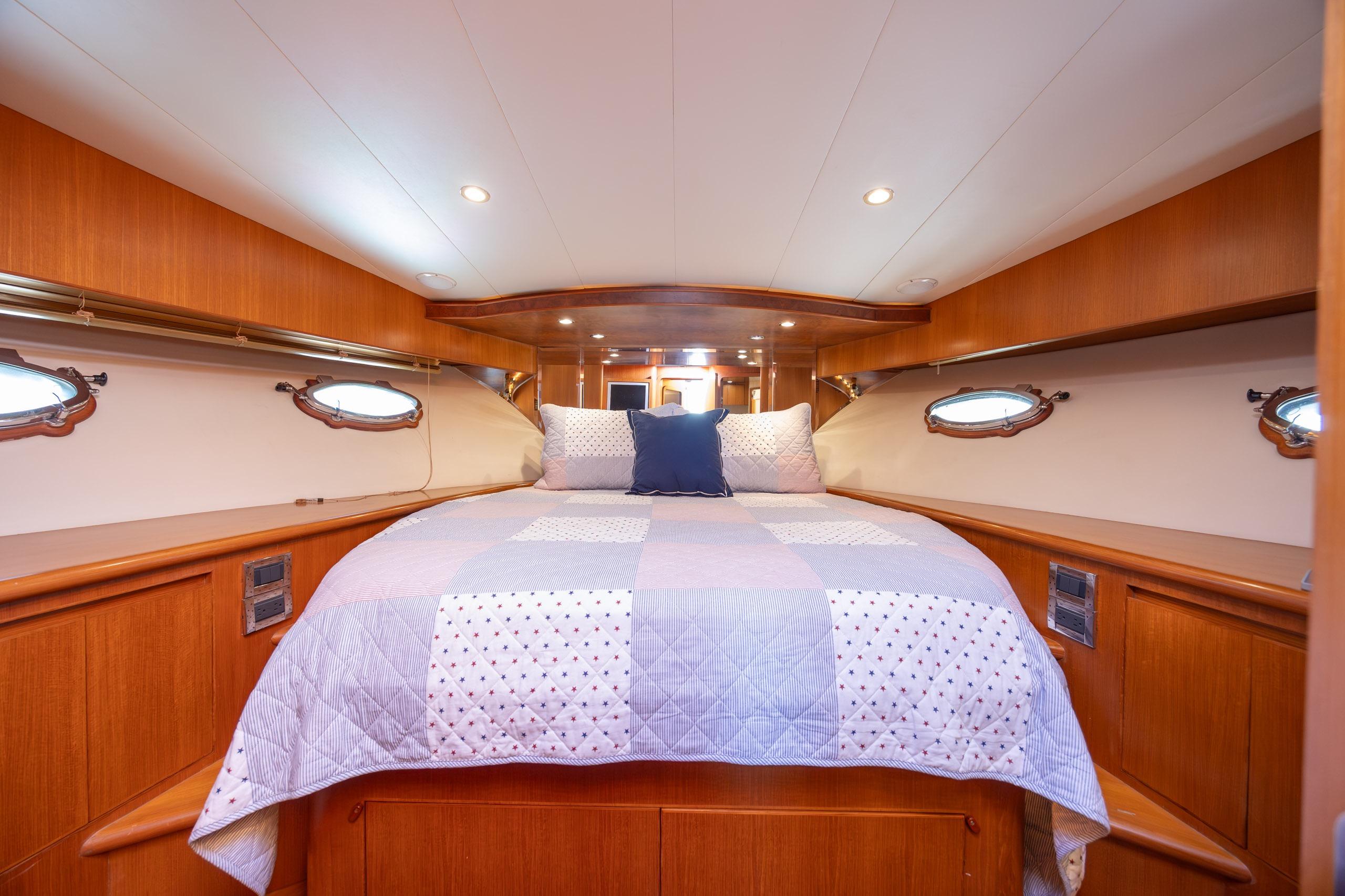 Luxurious cabin interior of 2005 Ocean Alexander 52 Sedan yacht with cozy bedding.