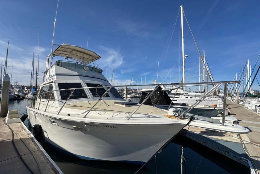 1985 Egg Harbor 33 Sedan yacht docked at marina under clear blue sky.