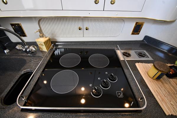 Modern kitchen stove in 1997 Sea Ray 400 Sundancer yacht, featuring sleek black cooktop design.