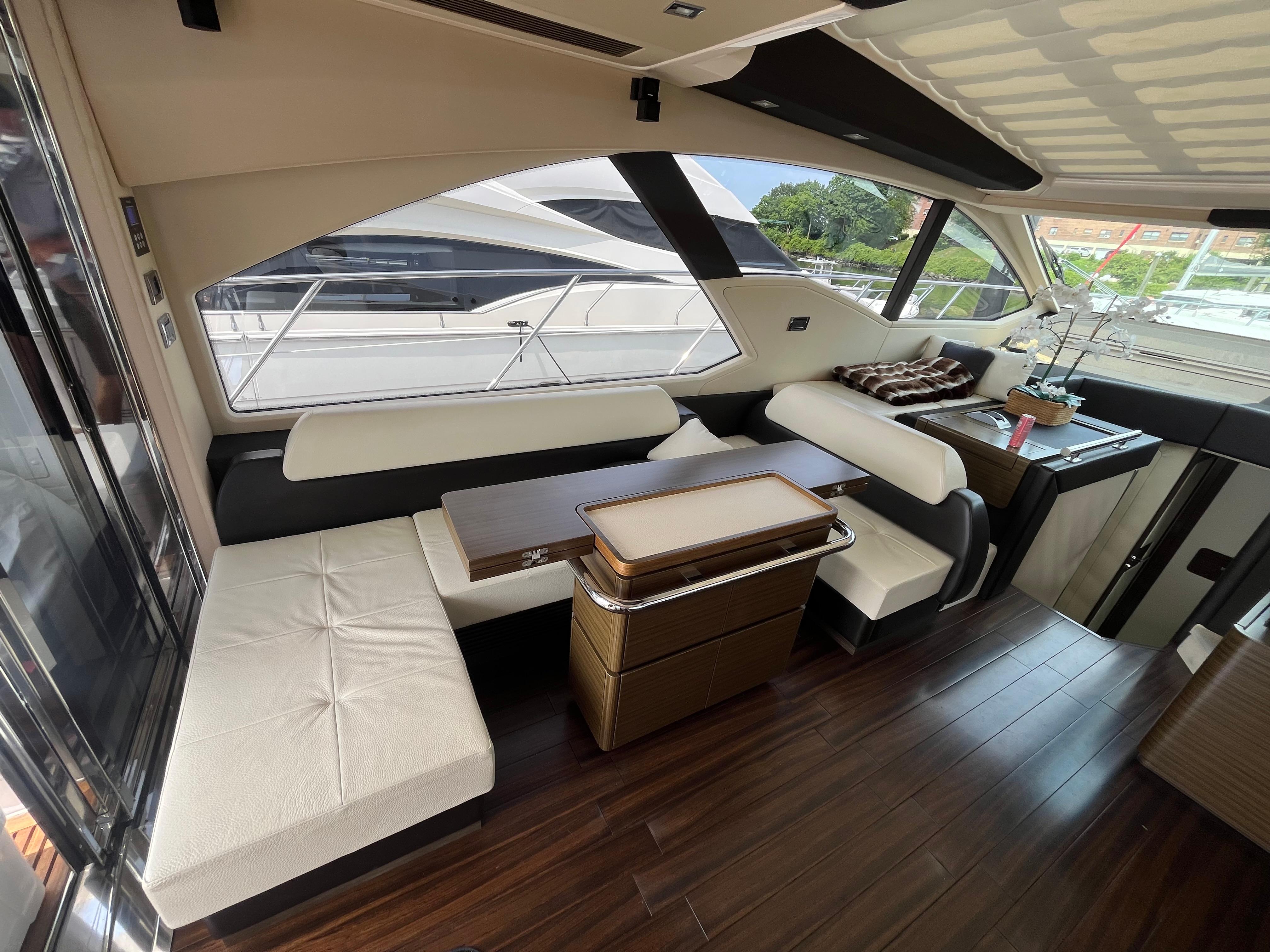 Luxurious interior of a 2014 Azimut 55S yacht with elegant seating and wooden flooring.