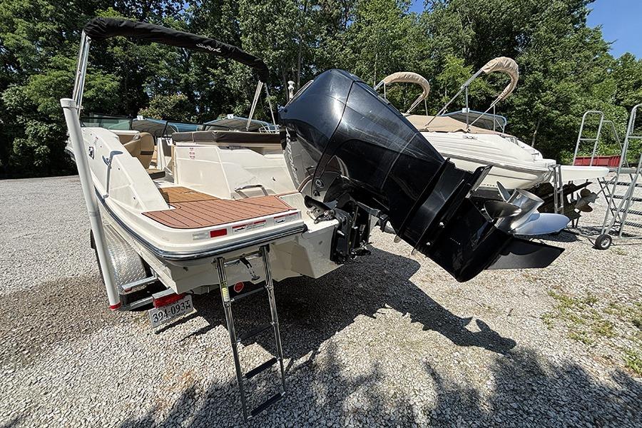 2019 Sea Ray SPX 230 Outboard boat with powerful engine, parked on gravel lot.