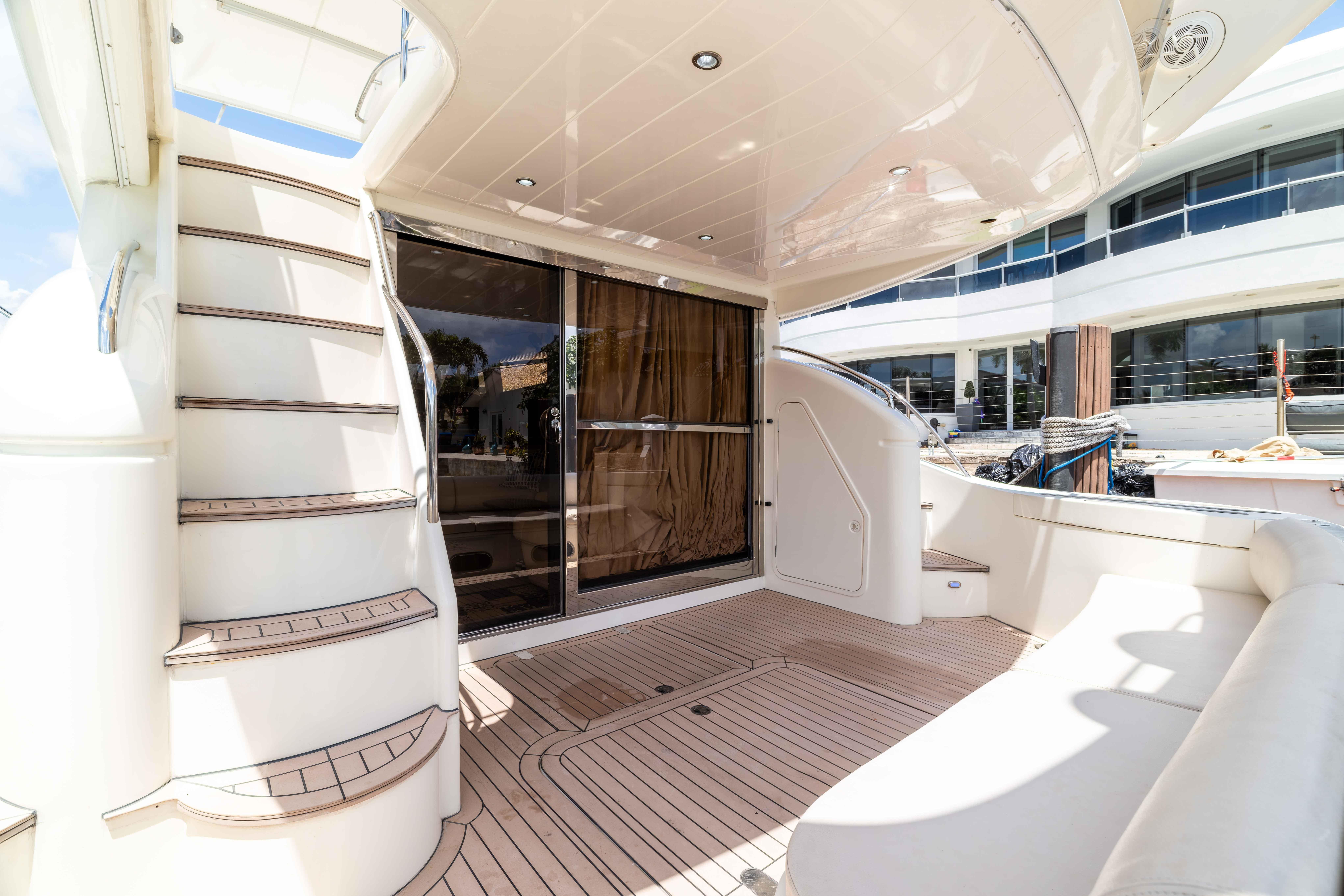 Luxurious 2002 Princess 61 yacht deck with elegant seating and staircase.
