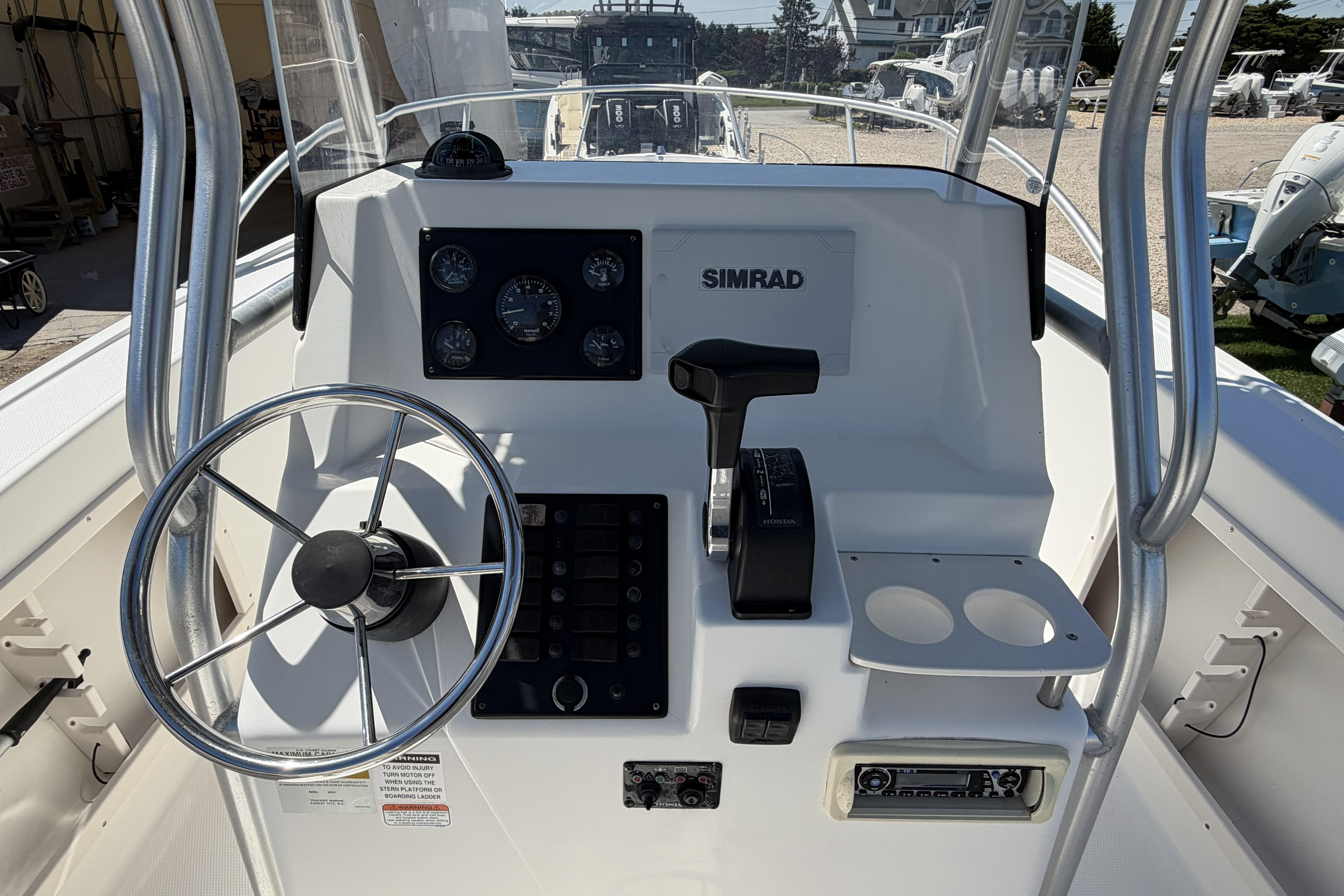 2006 Mako 212 Center Console boat dashboard with steering wheel and controls.