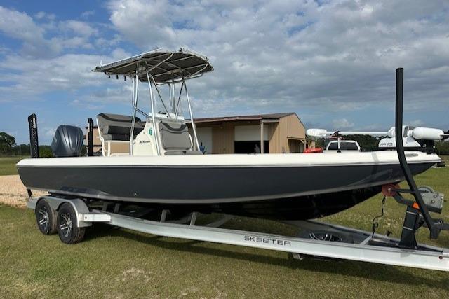 2023 Skeeter SX240 boat on trailer, parked outdoors under a cloudy sky.
