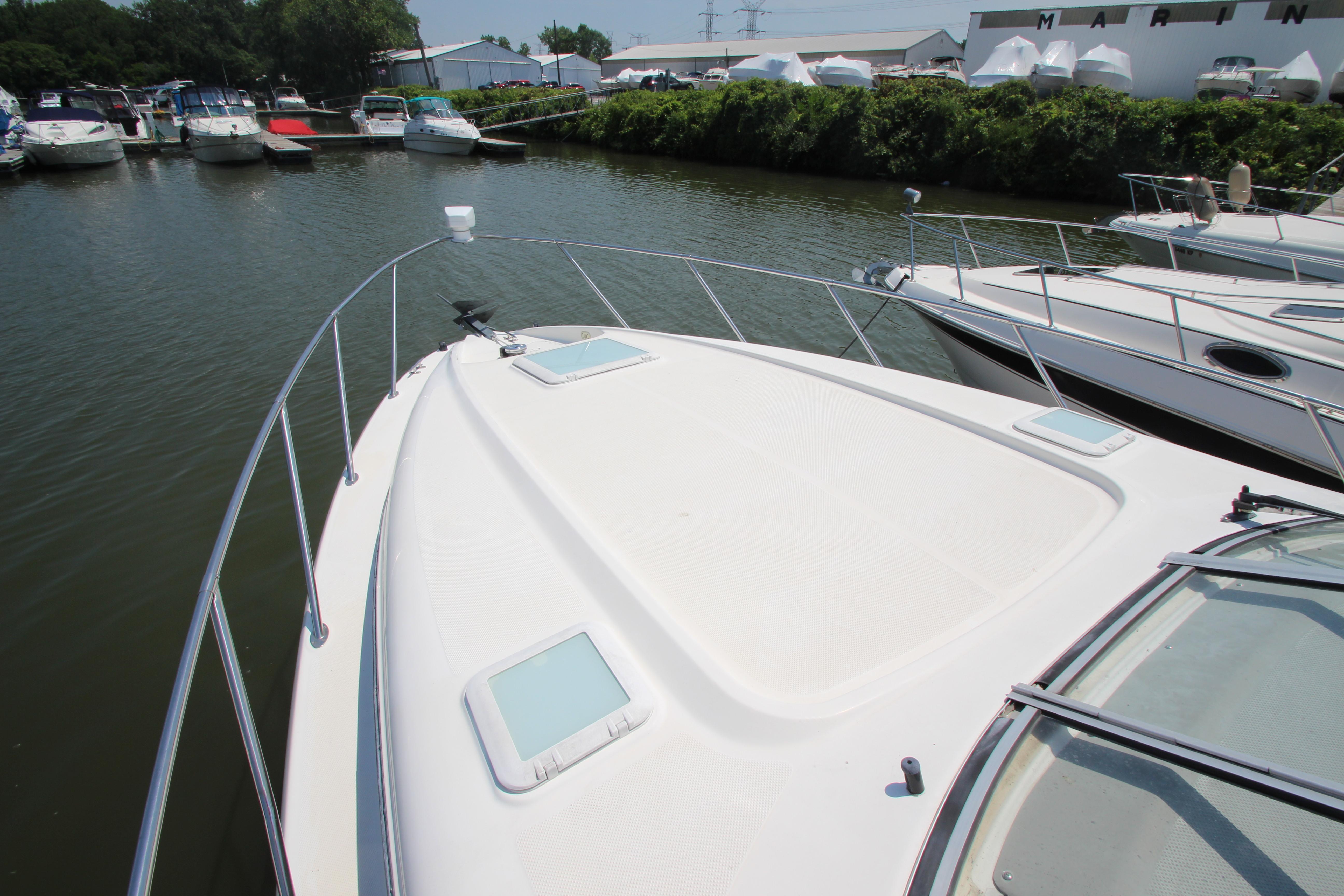 1999 Bayliner 3055 Ciera boat docked at marina, surrounded by other boats.