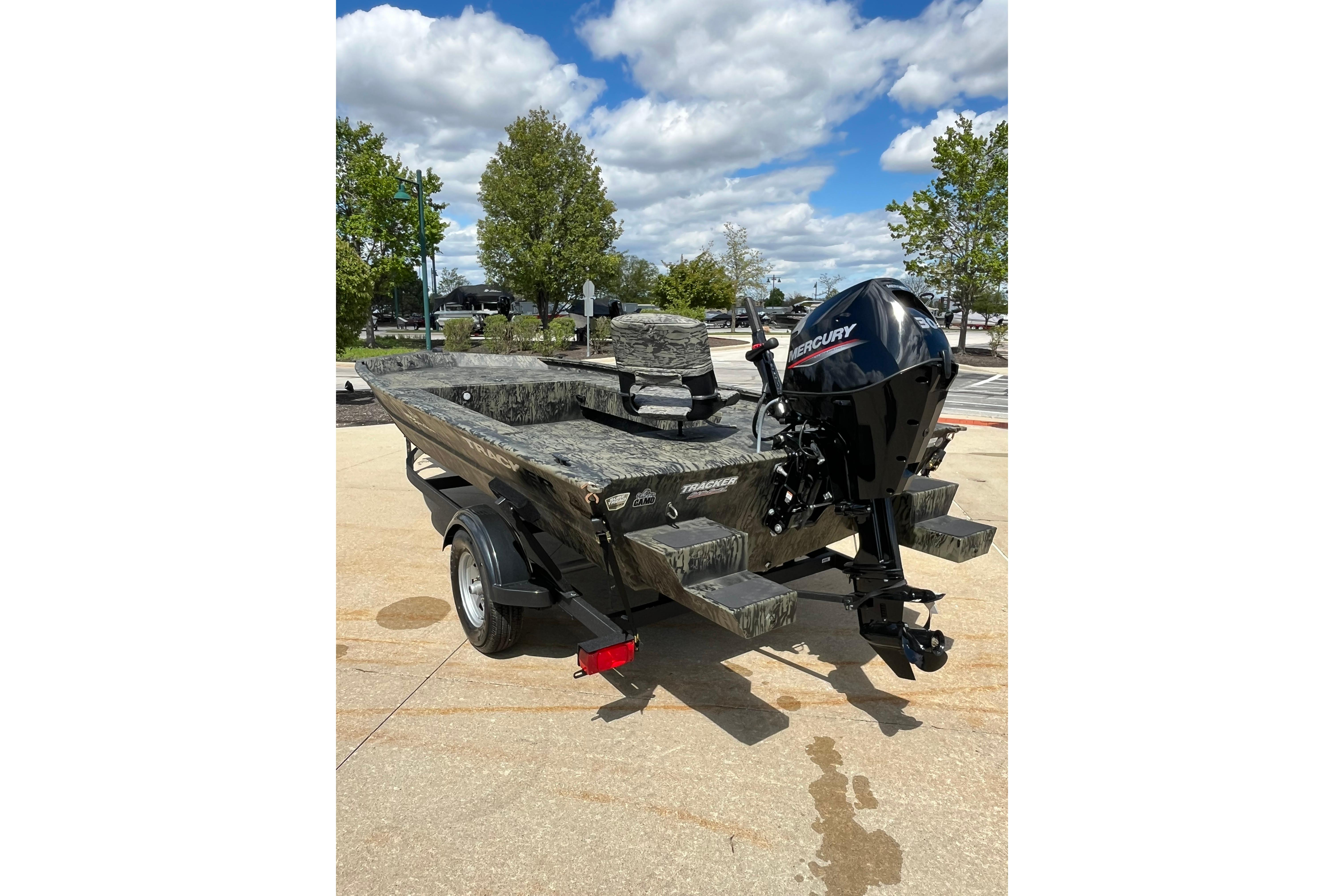 2026 Tracker Grizzly 1654 T Sportsman boat with Mercury engine, parked outdoors.