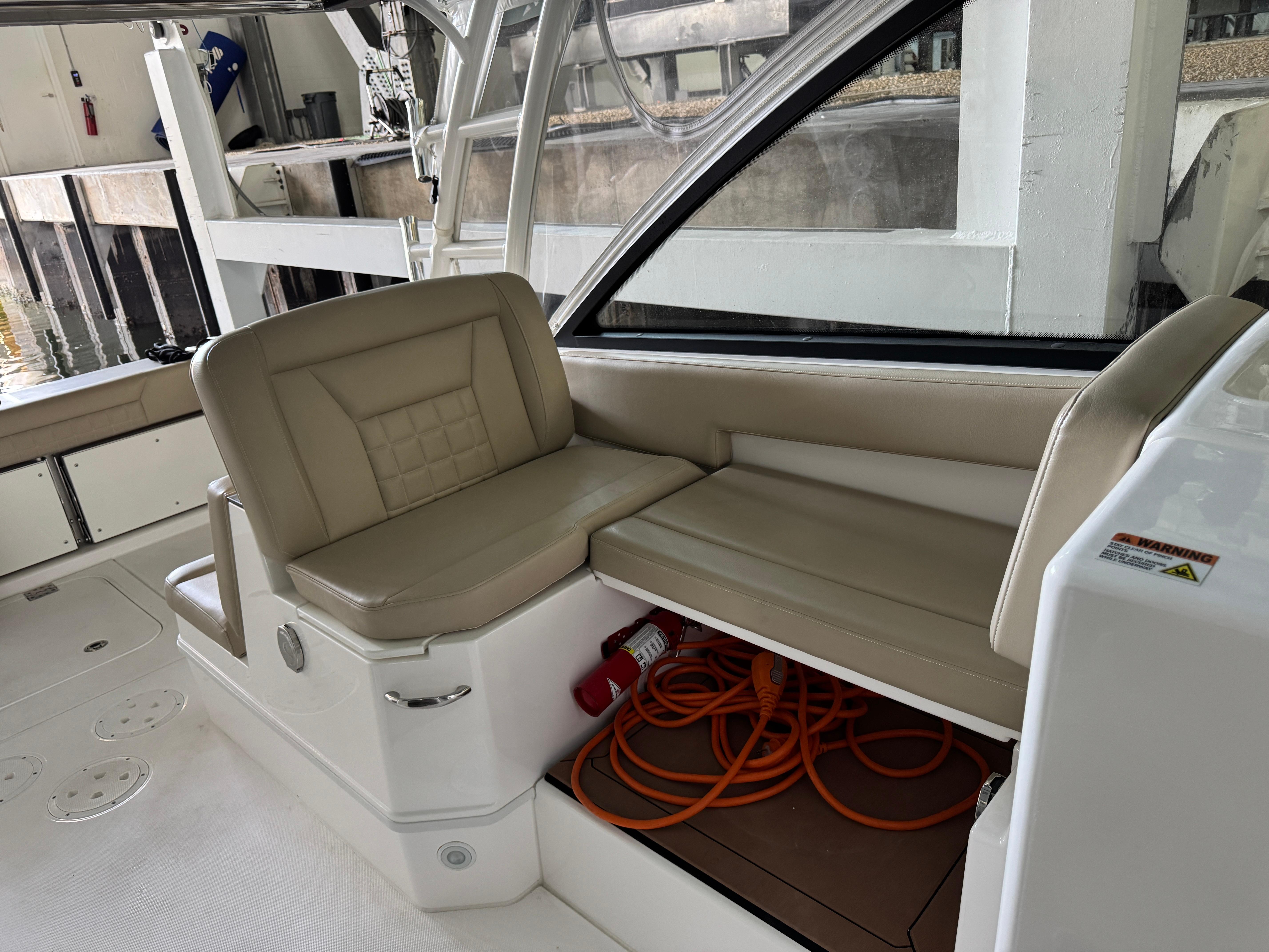 2019 Everglades 340 Dual Console boat interior with beige seating and storage compartment.