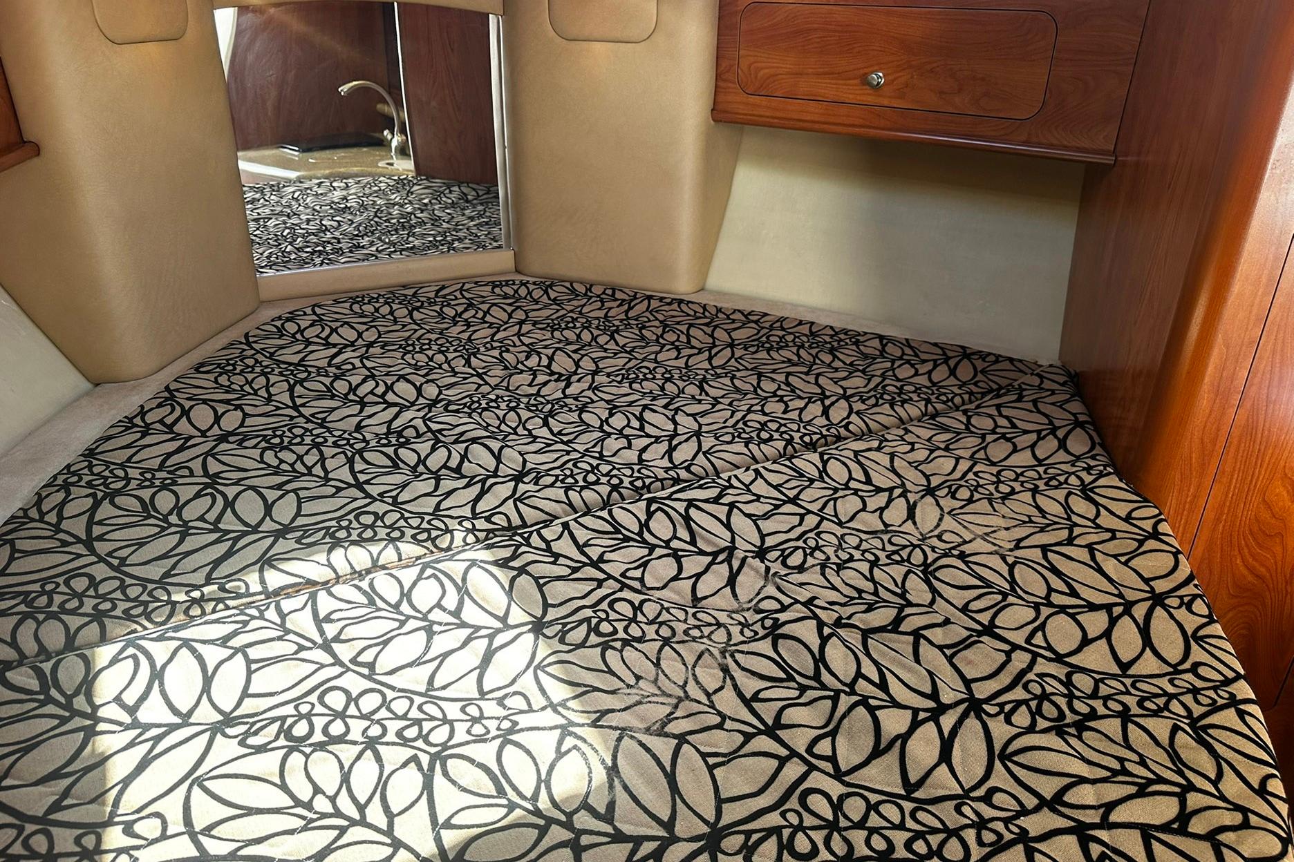 Interior of 2012 Rinker 310 Express Cruiser LE with patterned carpet and wooden cabinetry.