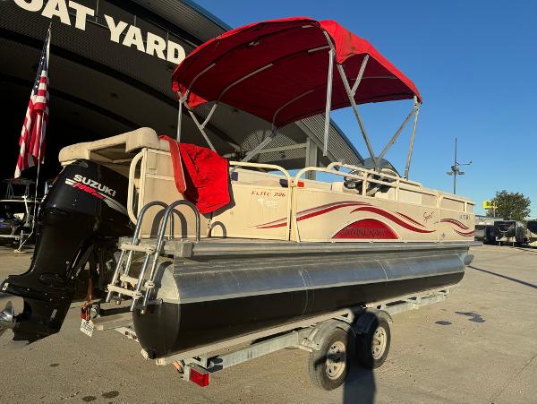 2005 Starcraft 22 Sport pontoon boat with red canopy on trailer at boat yard.