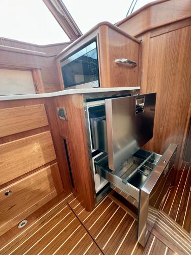 2025 Sabre 43 Salon Express interior with modern wood cabinetry and stainless steel appliances.