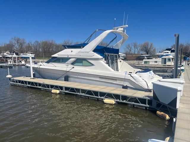 1995 Sea Ray 440 Express Bridge yacht docked at marina on a sunny day.