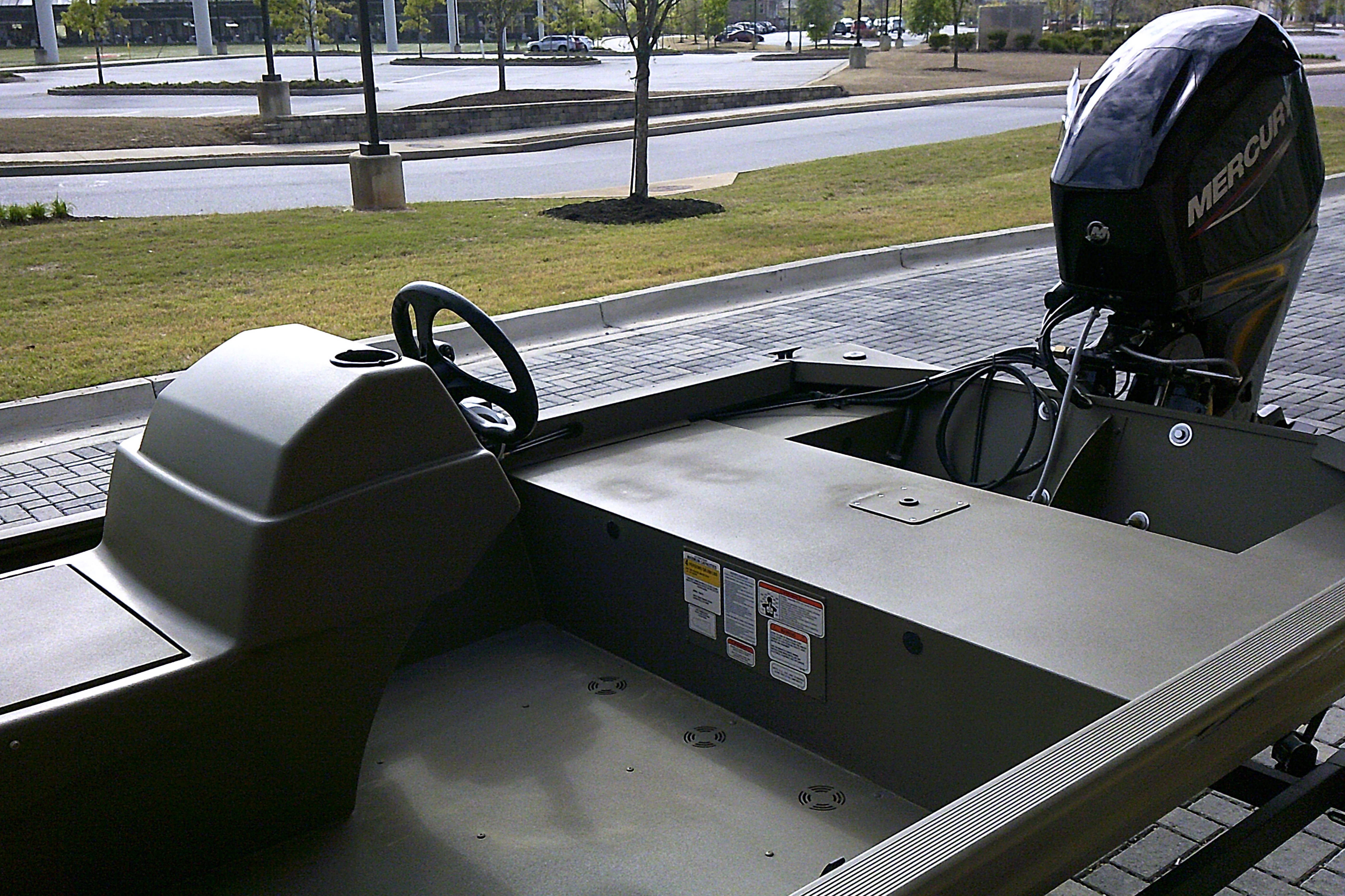 2026 Tracker Grizzly 1648 SC boat with Mercury outboard motor, parked on paved area.