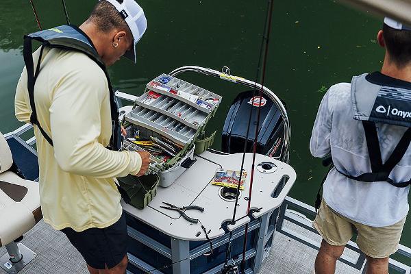 Manufacturer Provided Image: Two people fishing on a 2024 Lowe SF 214 boat, organizing tackle box.