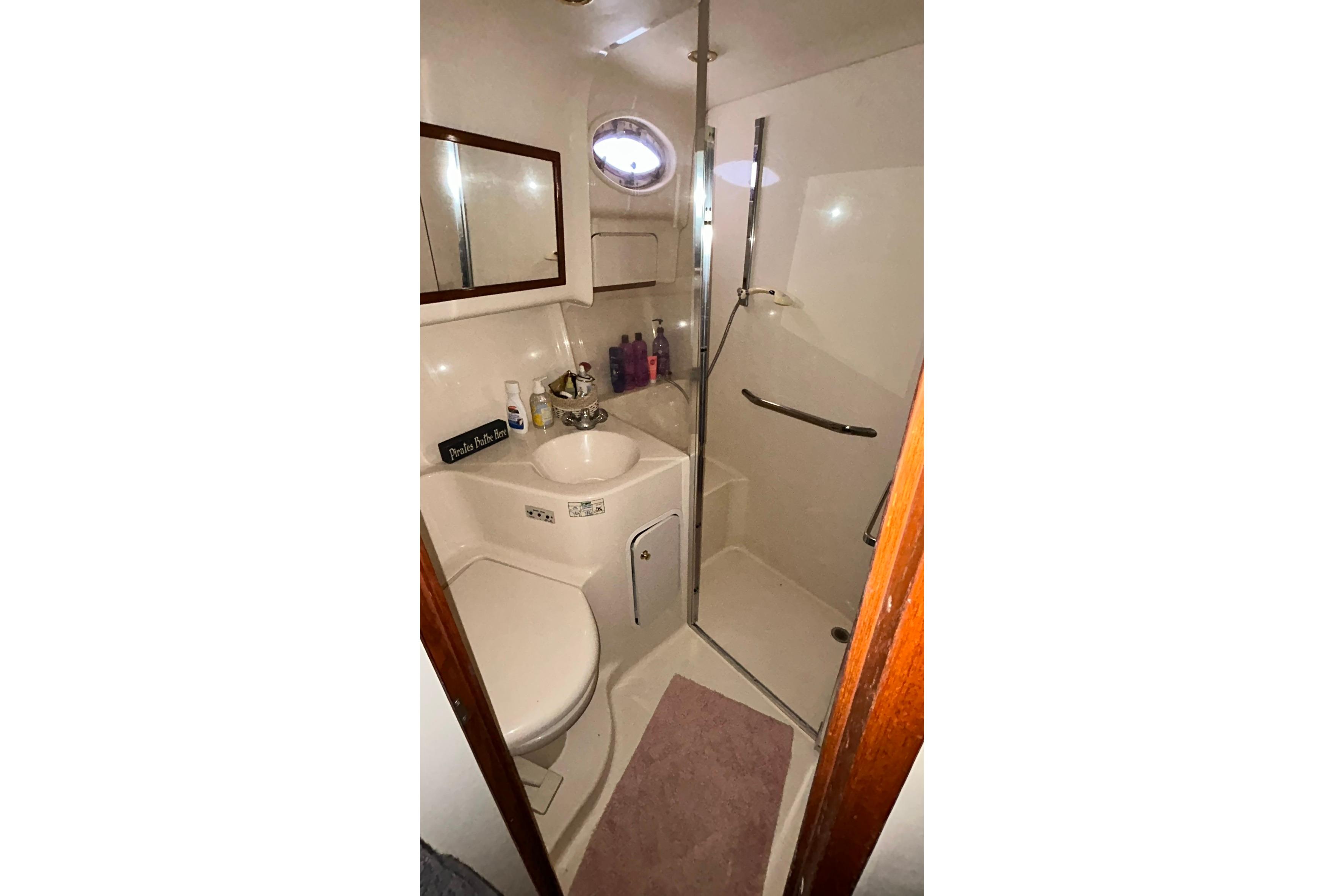 Bathroom interior of 1999 Sea Ray 400 Sedan Bridge yacht, featuring shower and sink.