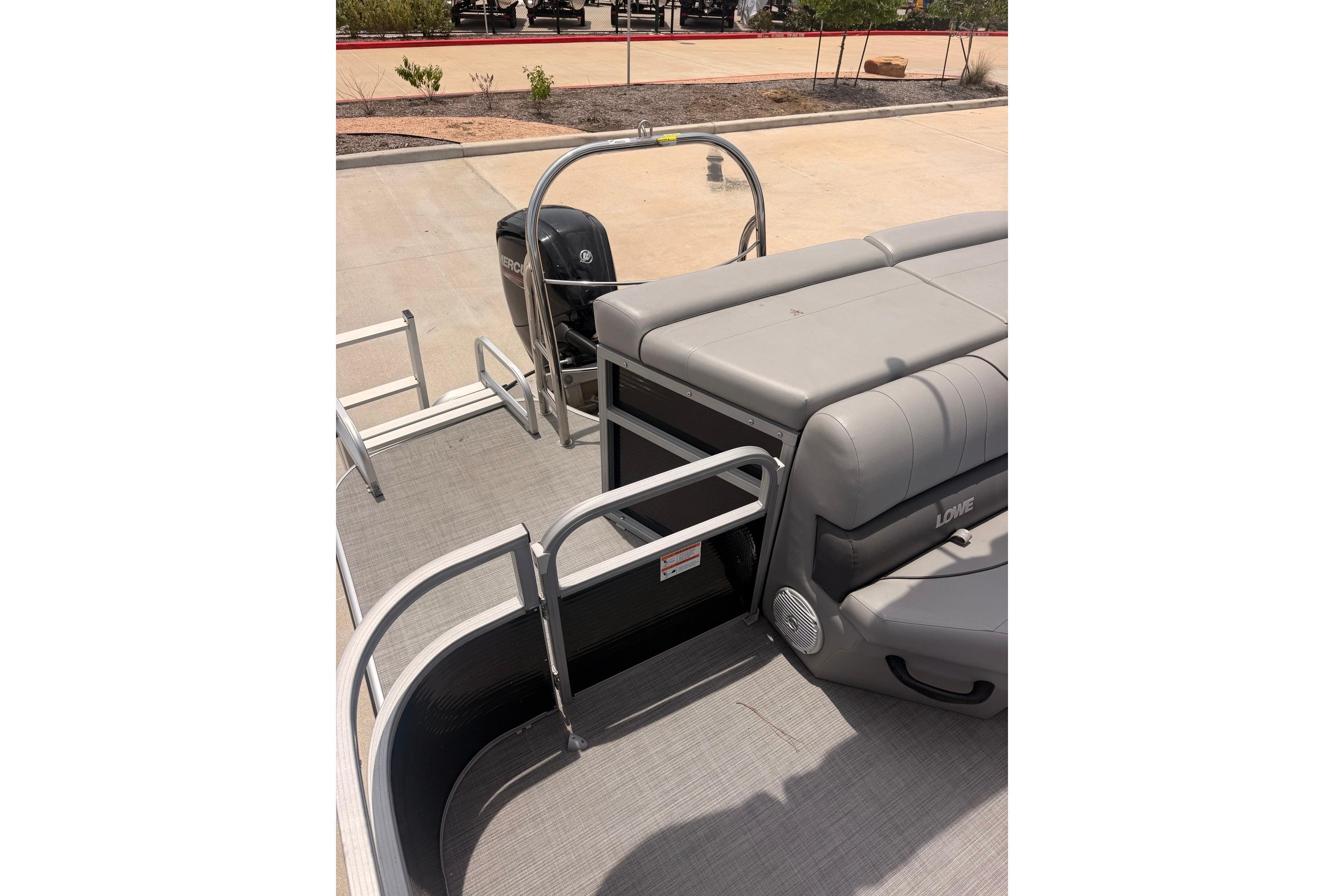 2021 Lowe SS 210 pontoon boat interior with seating and railing, parked on pavement.