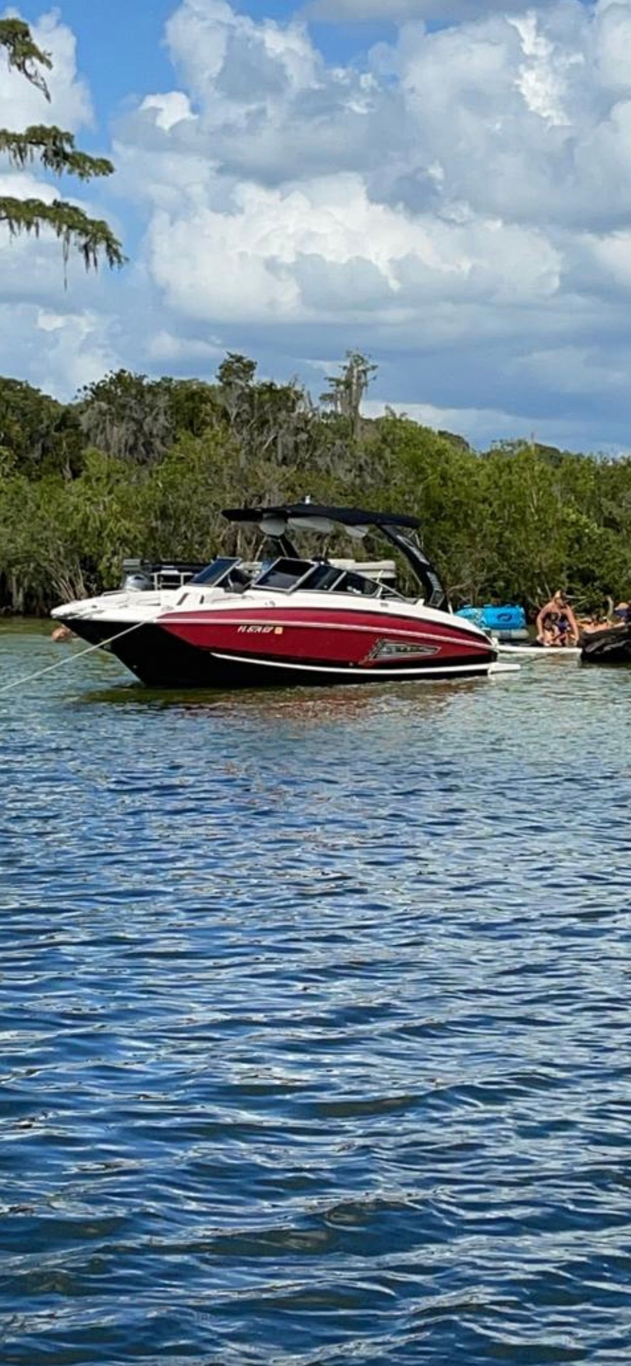 2016 Regal 27 FasDeck boat on calm water near trees.