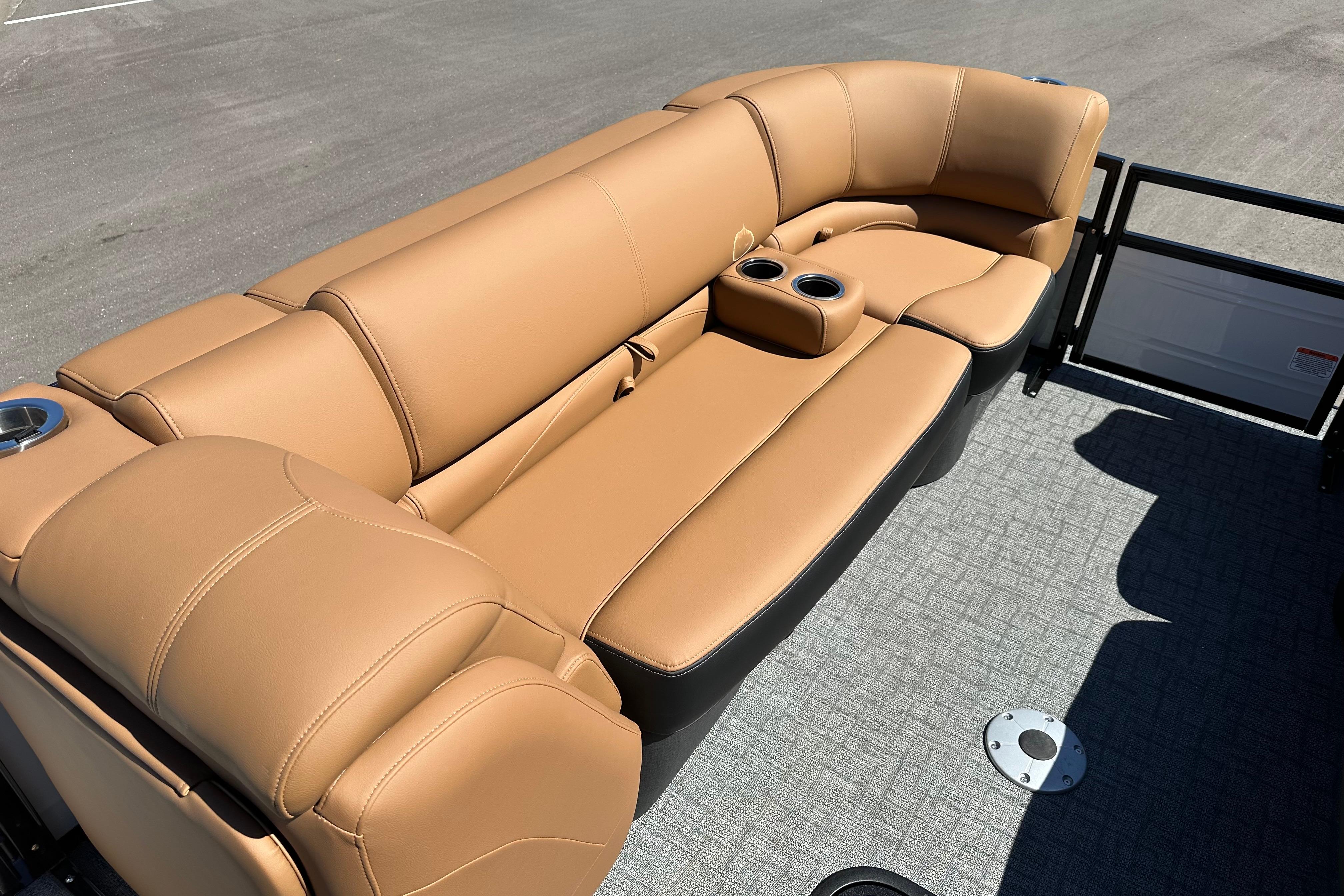 Luxurious tan seating on 2026 Regency 230 DL boat, featuring cup holders and sleek design.