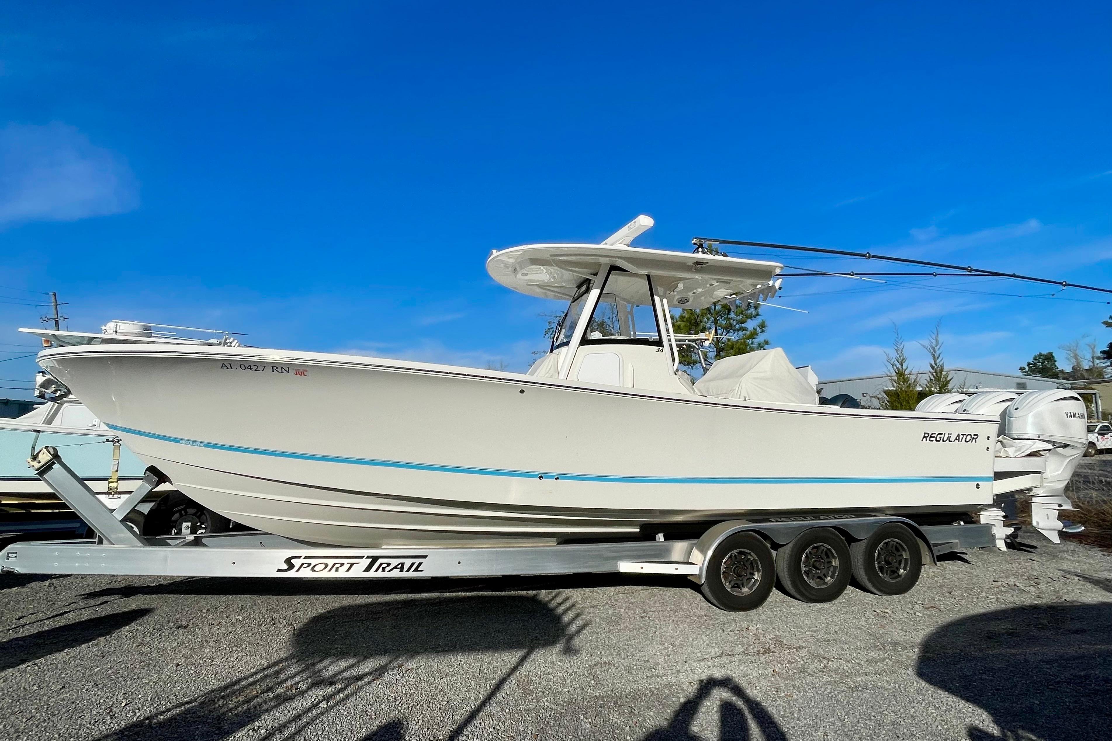 2023 Regulator 34 boat on Sport Trail trailer under clear blue sky.