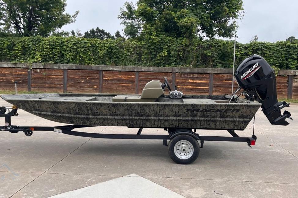 2026 Tracker Grizzly 1648 SC boat on trailer, parked outdoors.