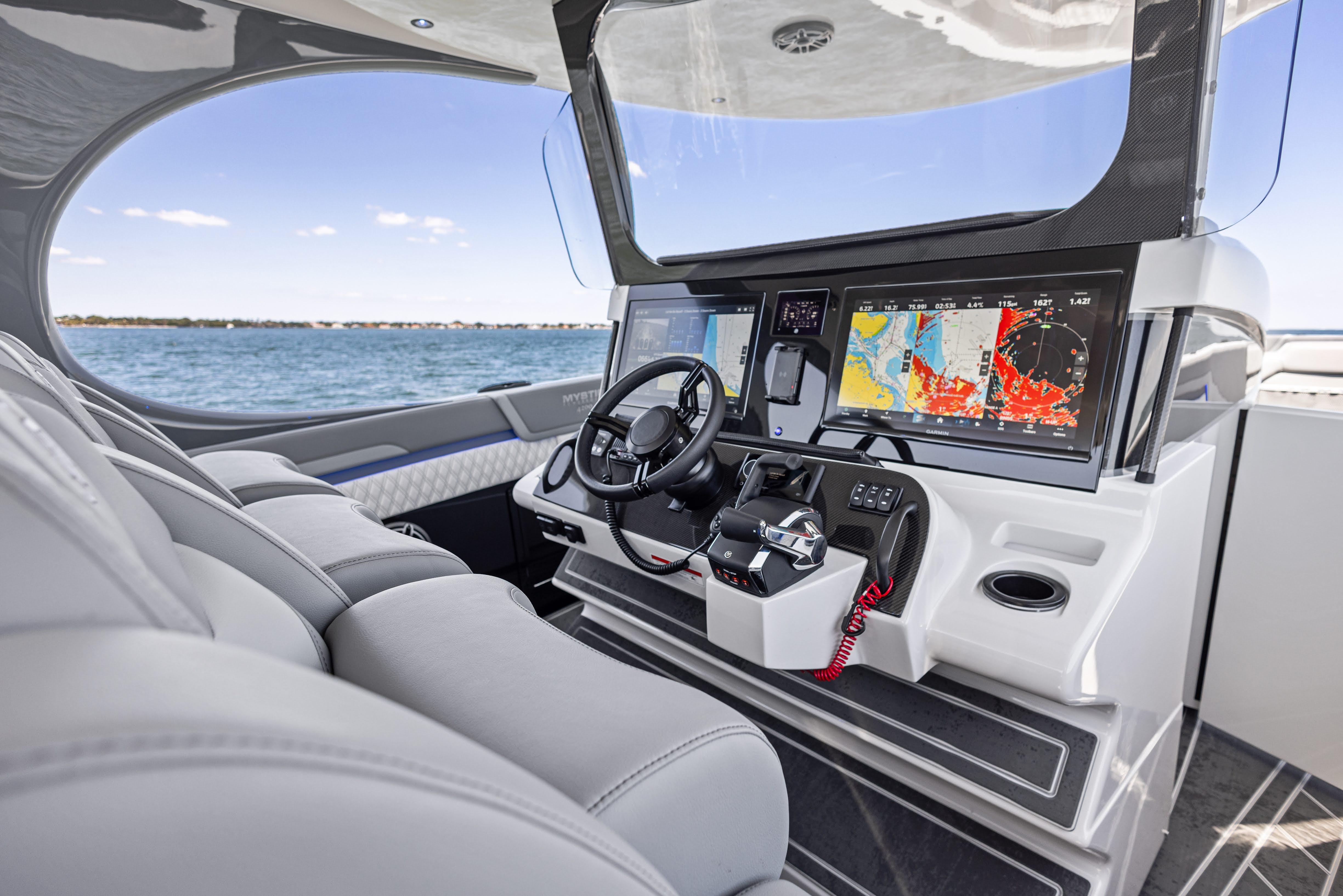 2026 Mystic Powerboats M4200 cockpit with advanced navigation displays and luxurious seating.