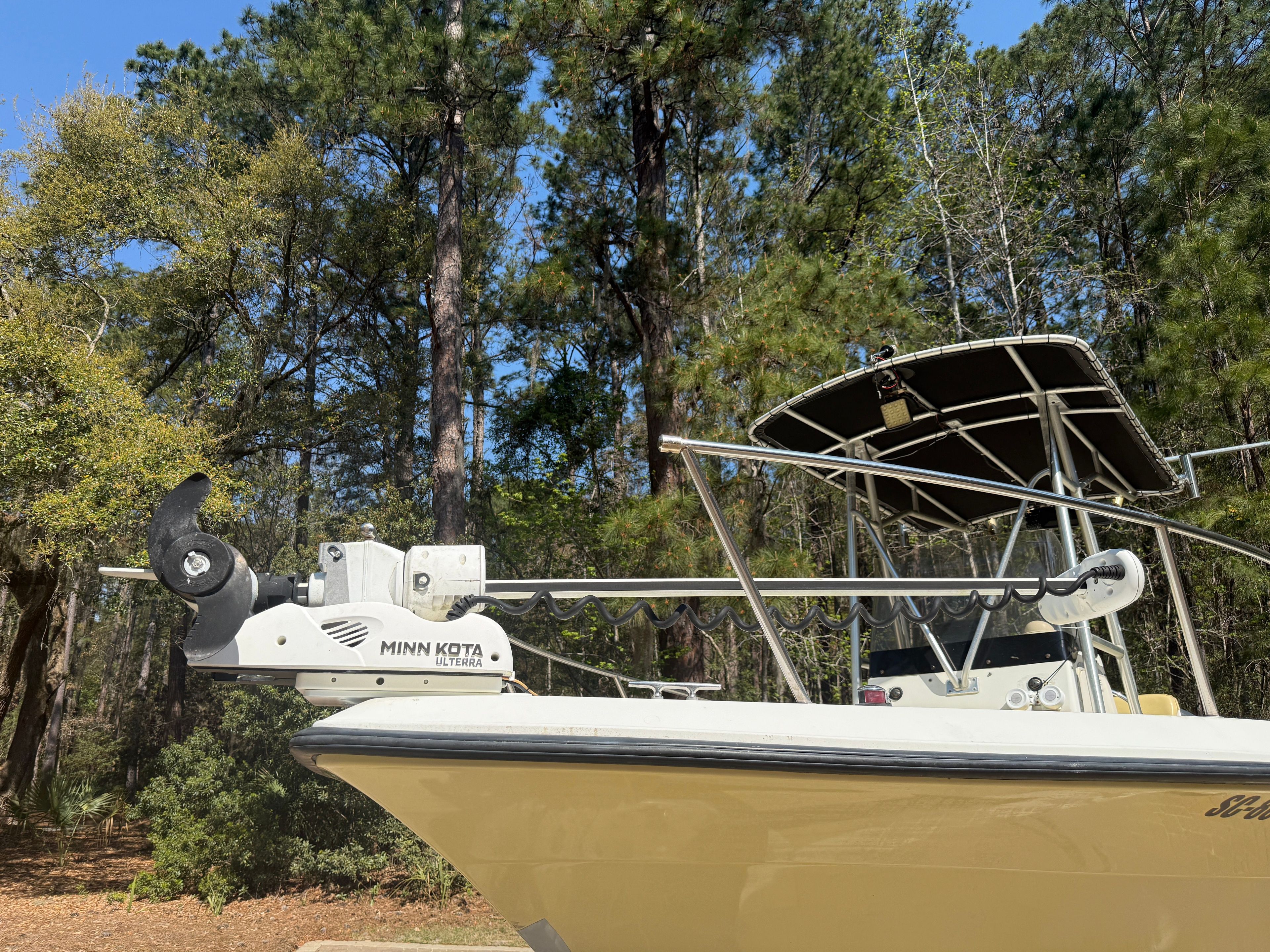 A boat with a Minn Kota motor, surrounded by trees in the background.