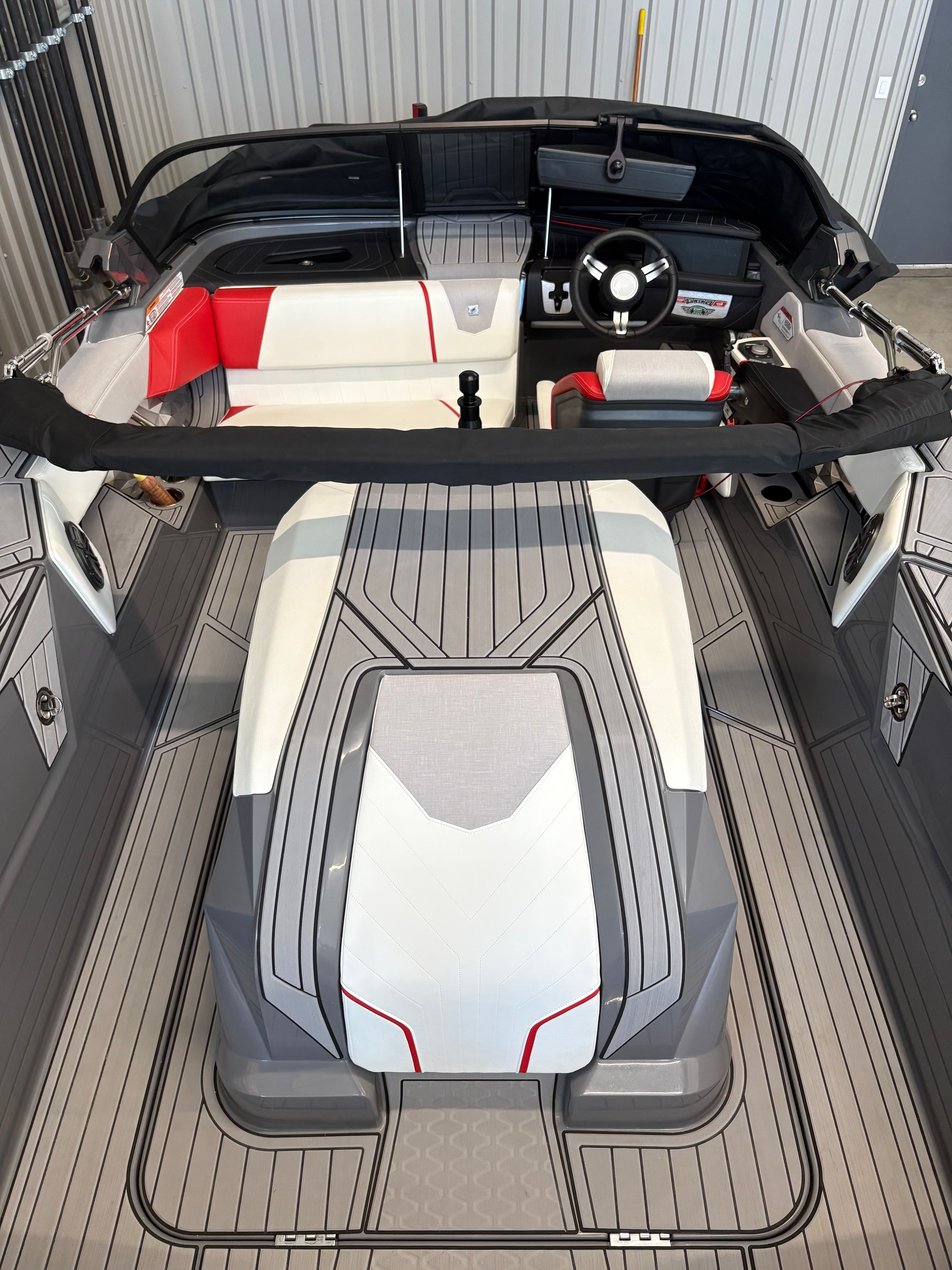 Interior of a modern boat with gray and white seating, steering wheel, and stylish design.