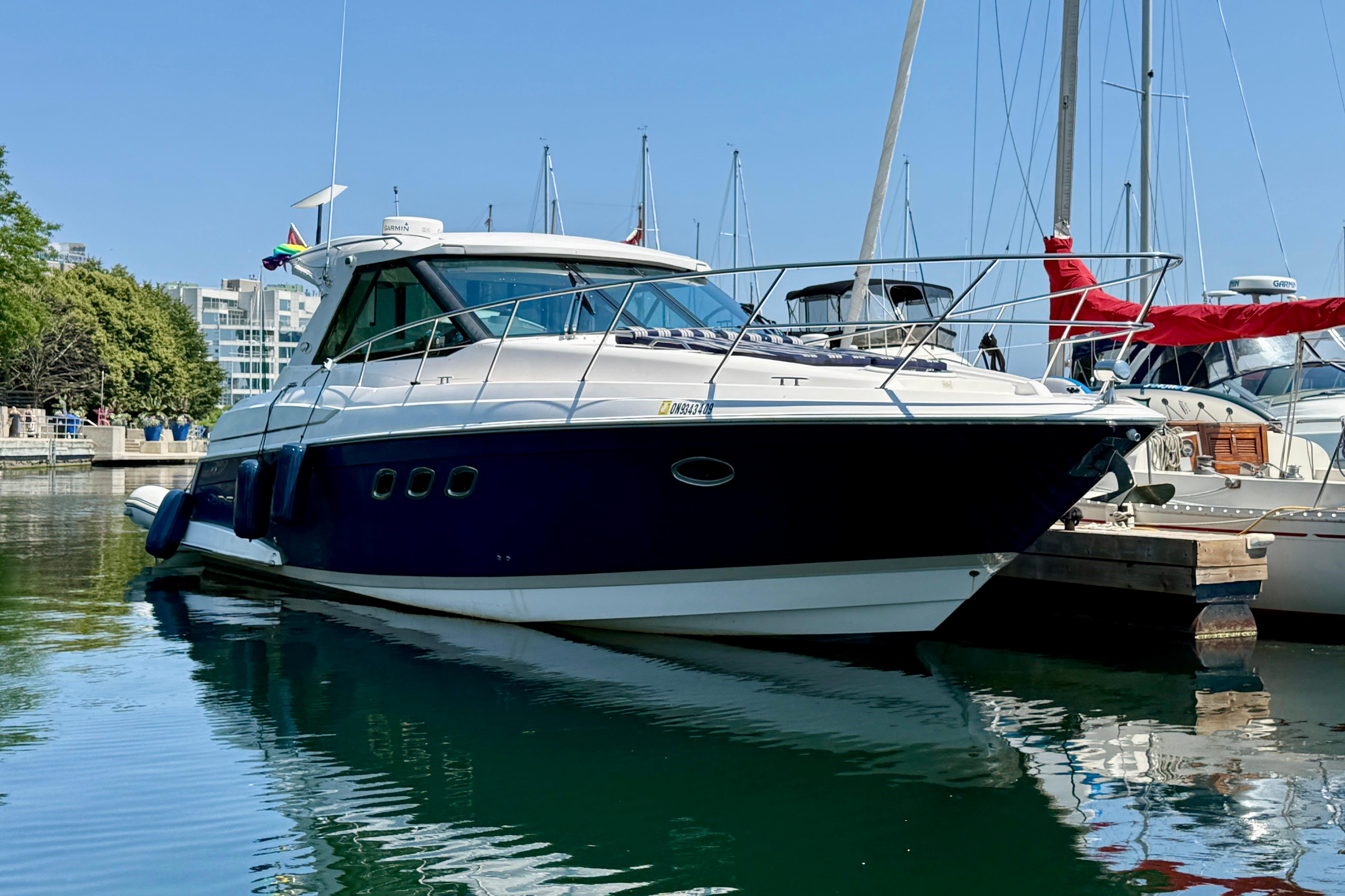 2012 Regal 42 Sport Coupe yacht docked in marina, surrounded by other boats.