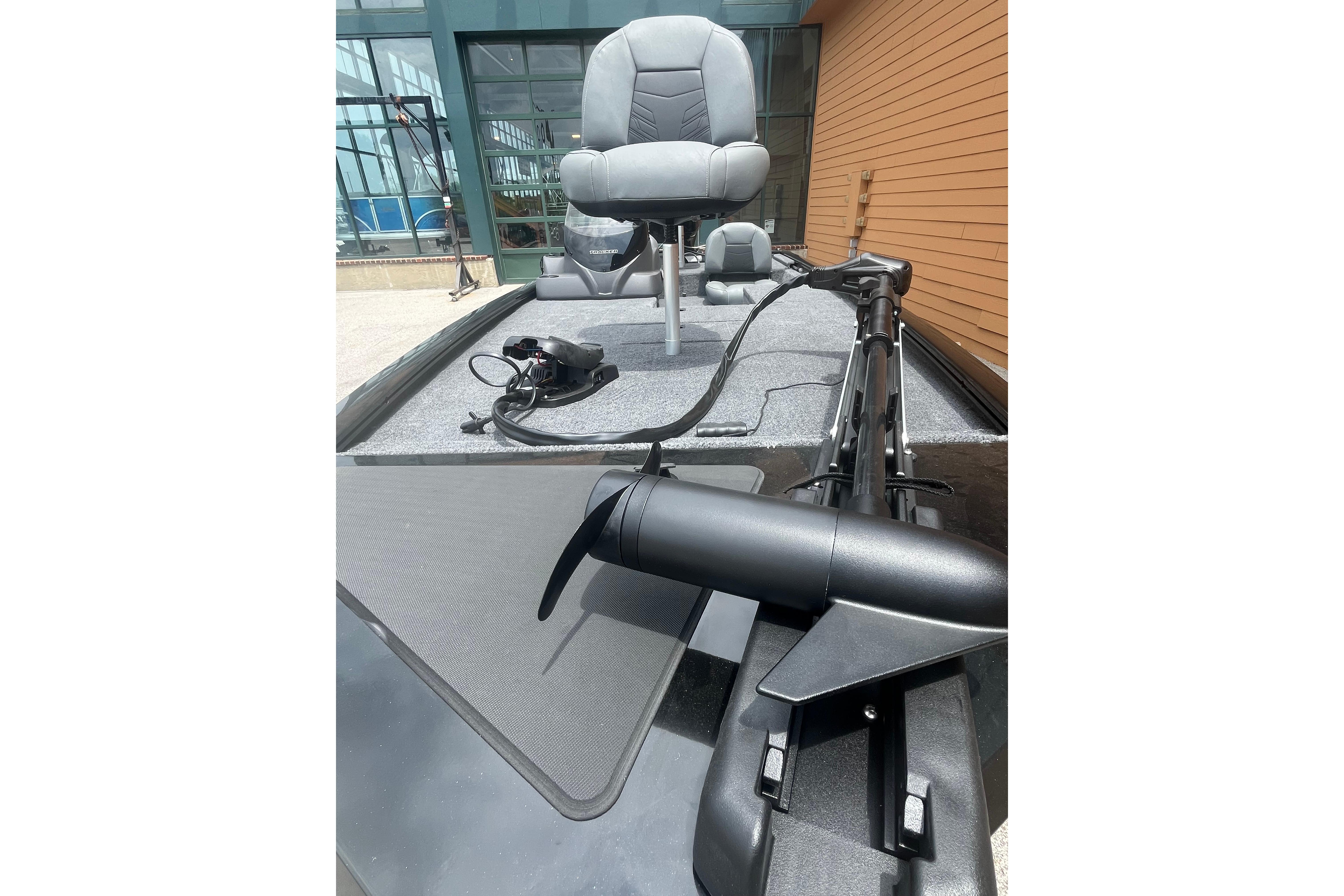 2026 Tracker Pro 170 boat deck with seating and trolling motor, docked near a building.