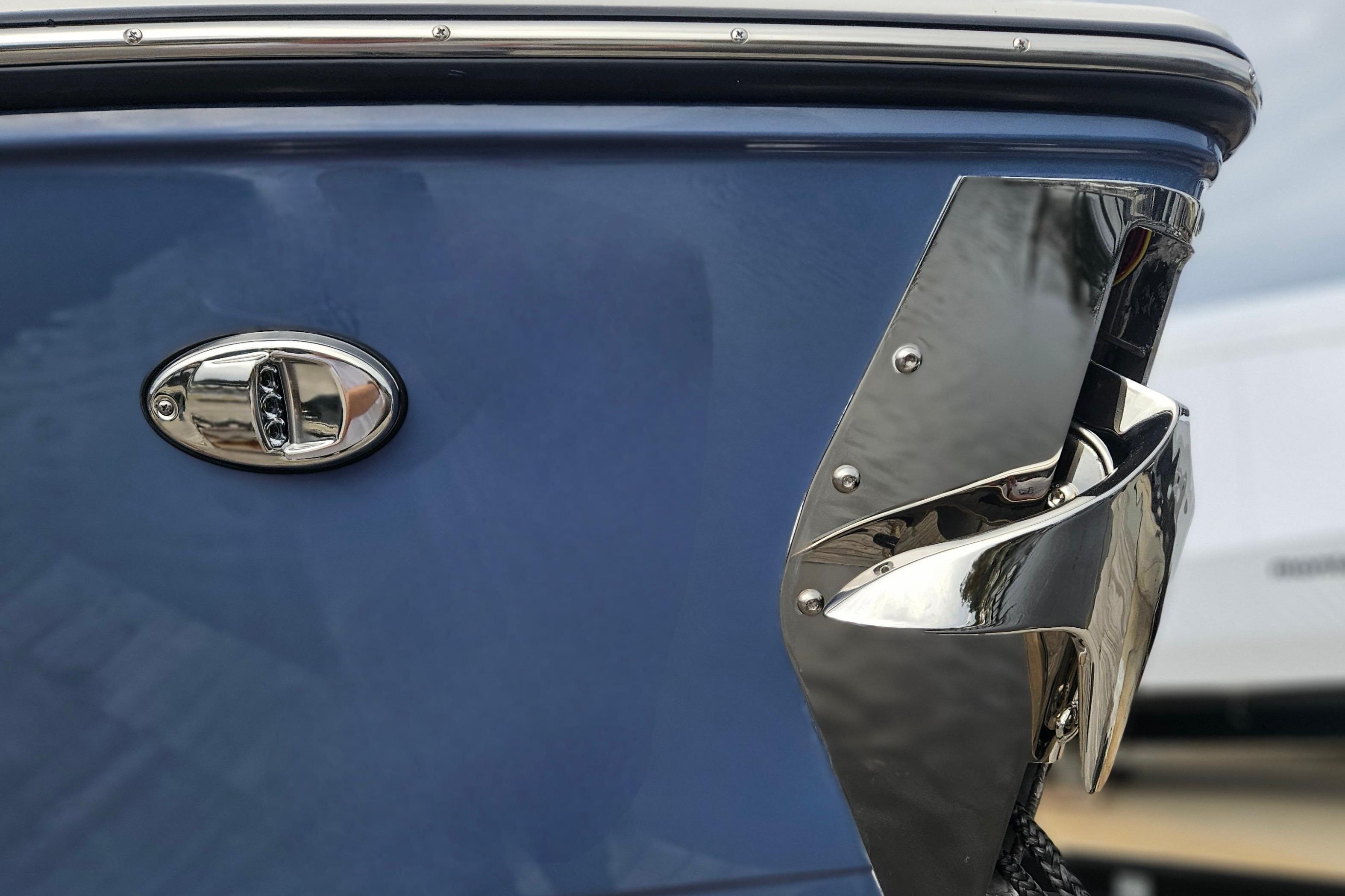 2026 Monterey Elite 27 OB boat, blue hull with chrome detailing, close-up view.