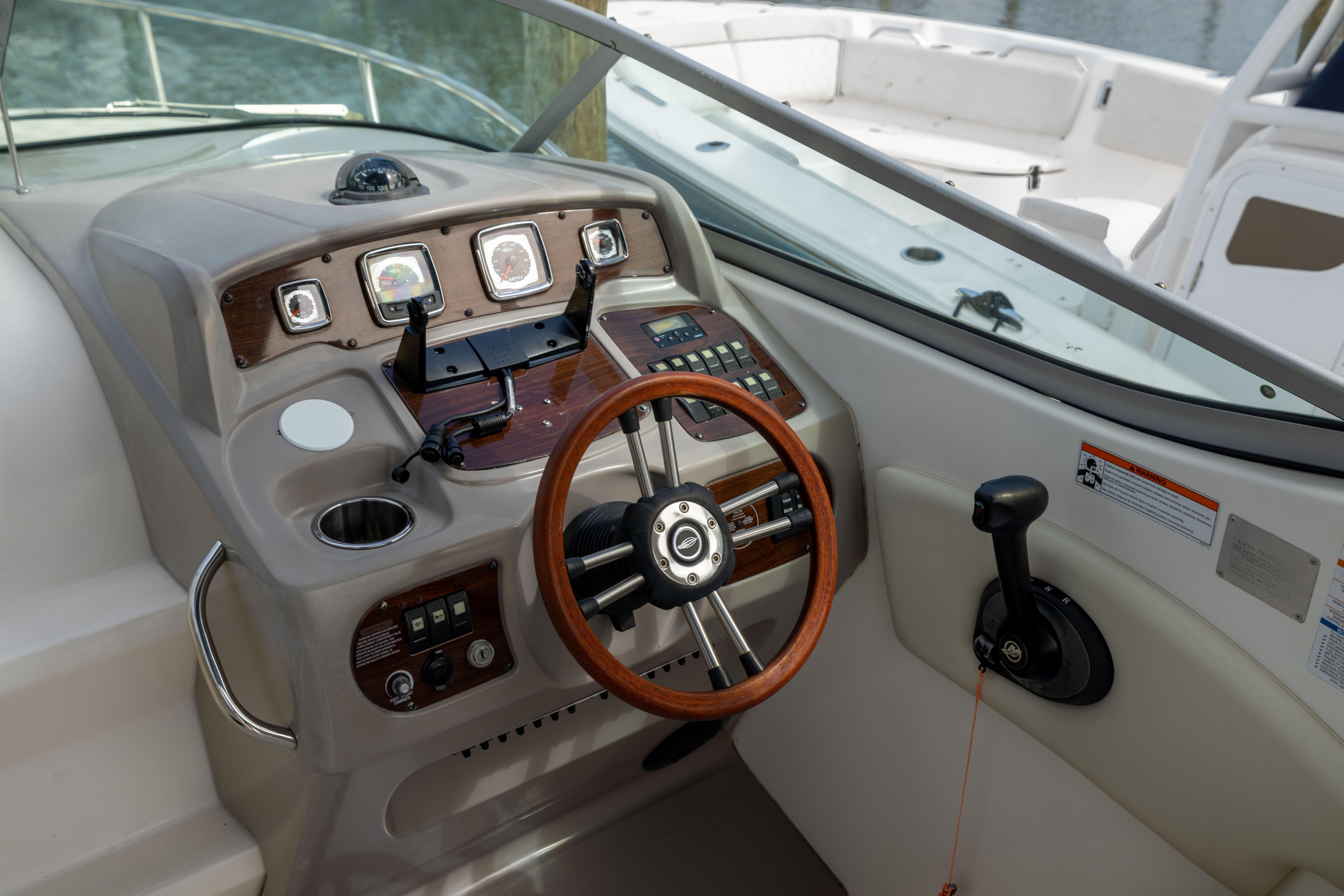 2008 Chaparral Signature 250 boat dashboard with steering wheel and control panel.