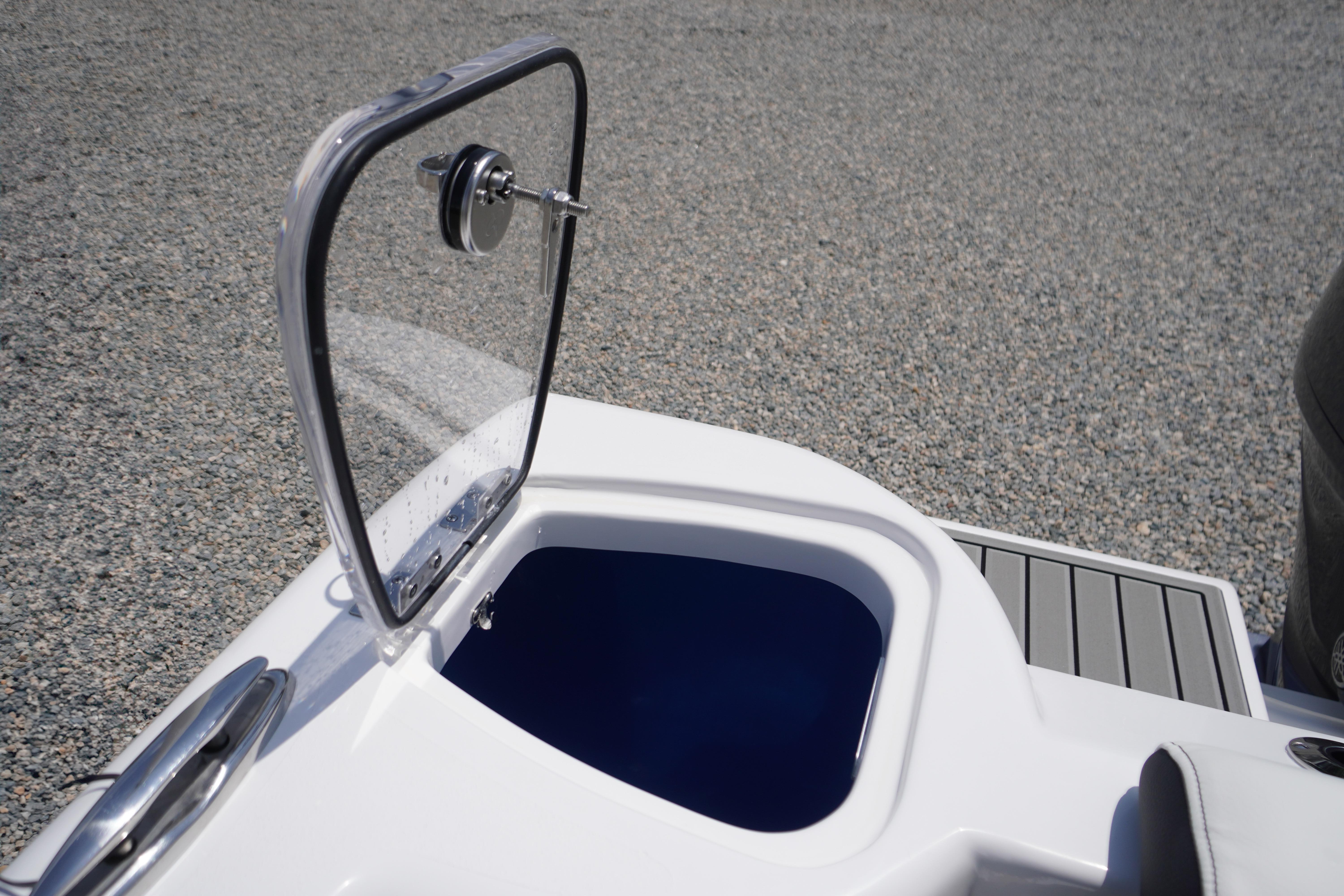 Open storage compartment on 2027 Tidewater 220 CC Adventure boat, featuring sleek design.
