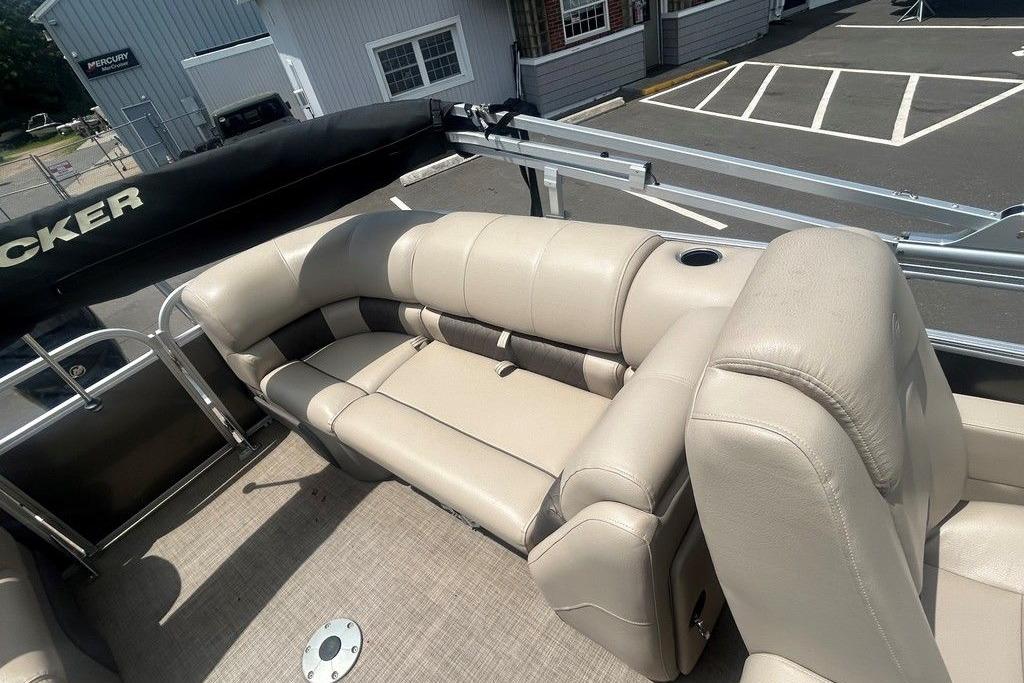 2023 Sun Tracker Party Barge 22 DLX with beige seating and cup holder on deck.