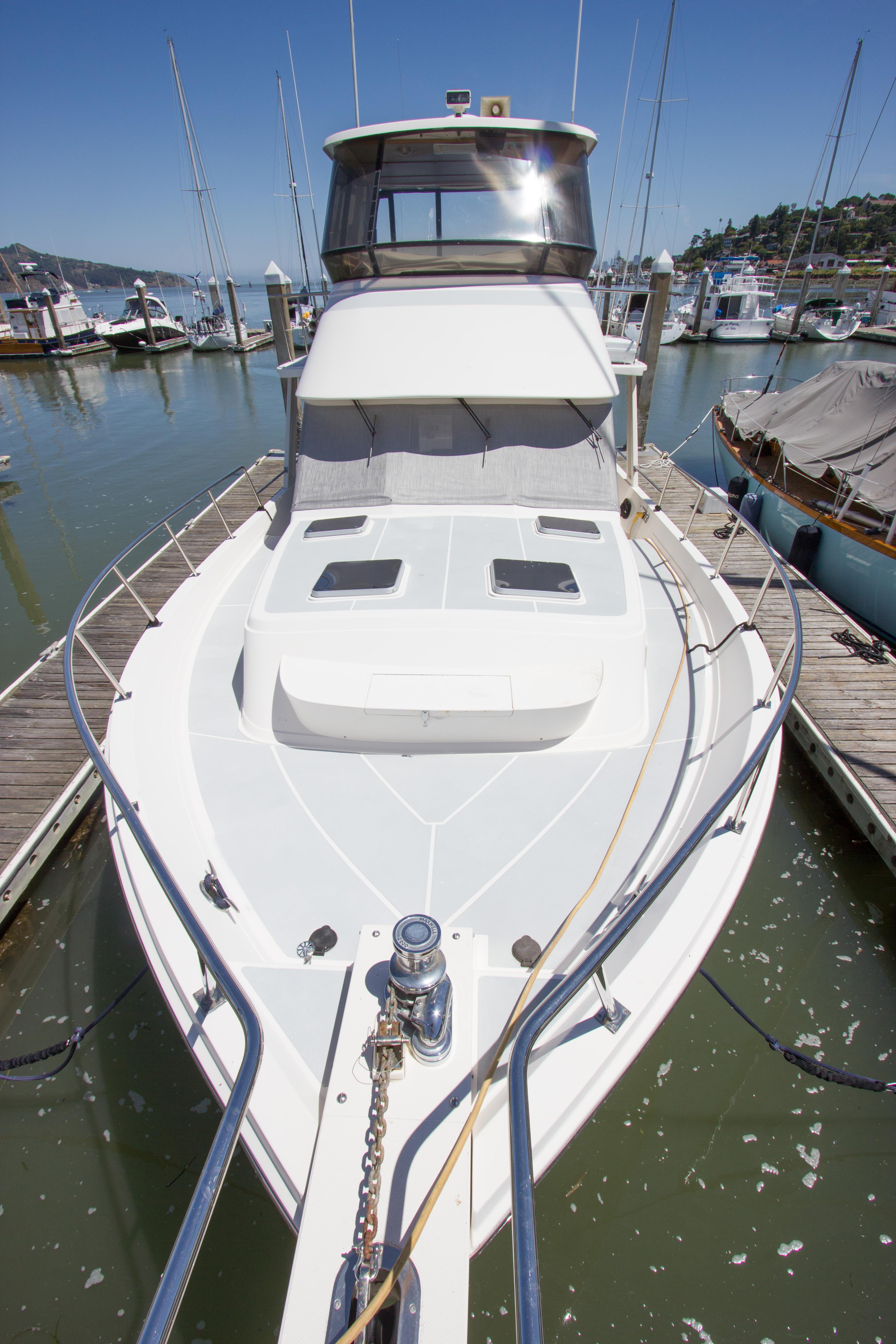 1992 Offshore Yachts Sedan docked at marina, showcasing sleek design and spacious deck.