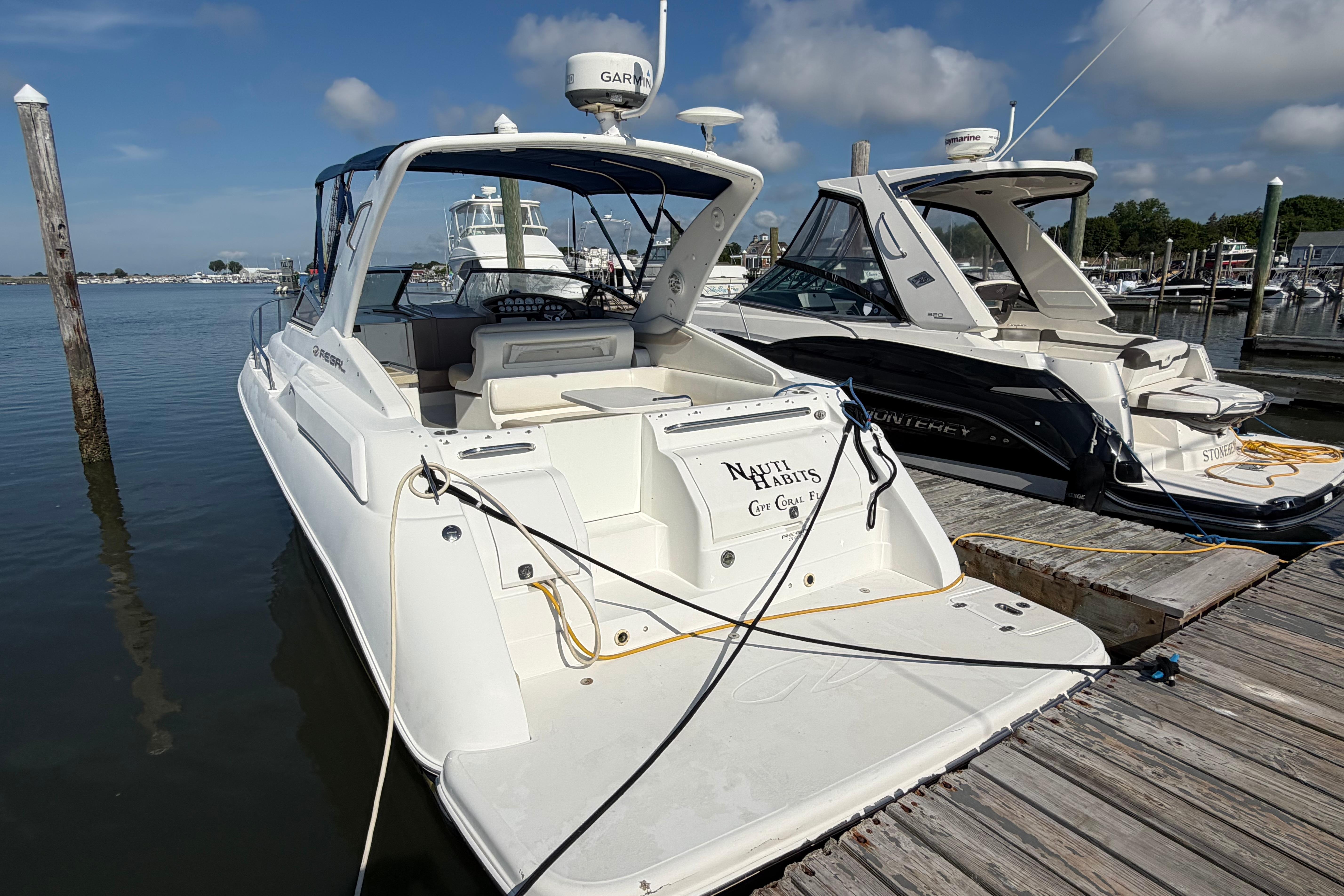 2003 Regal Commodore 3260 yacht docked at marina under clear blue sky.