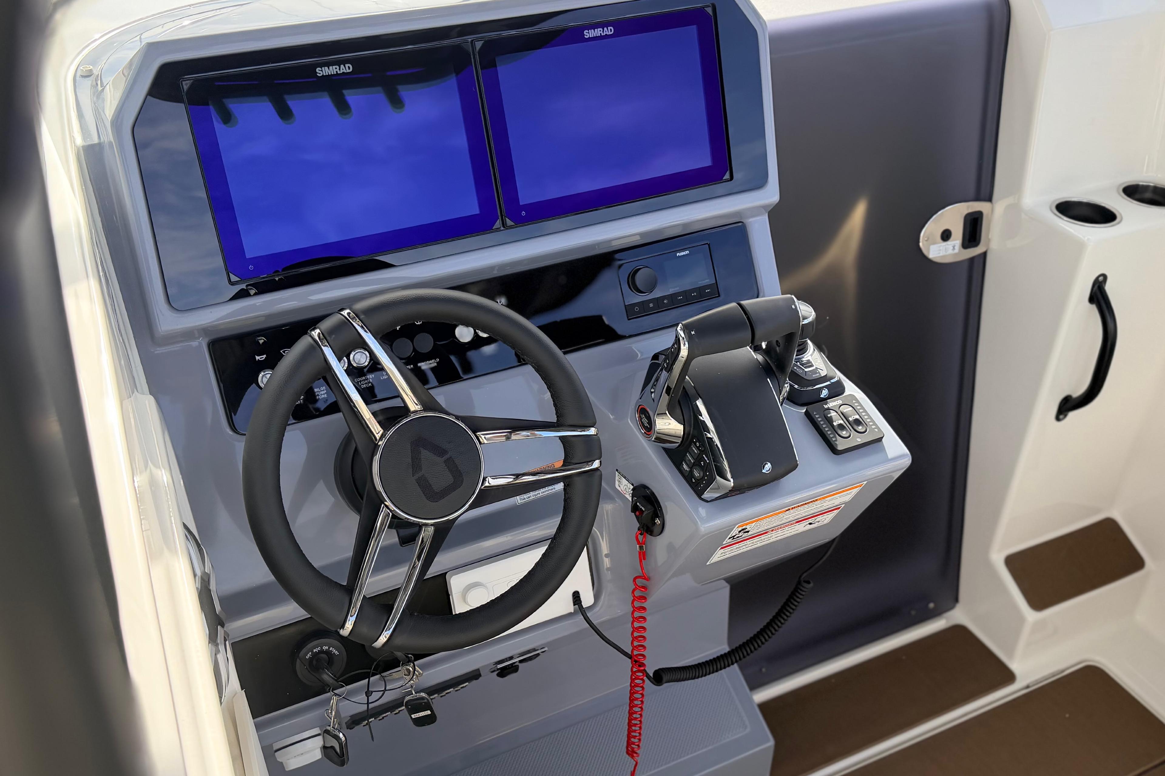 Control panel of 2026 Navan S30 boat with dual screens and steering wheel.