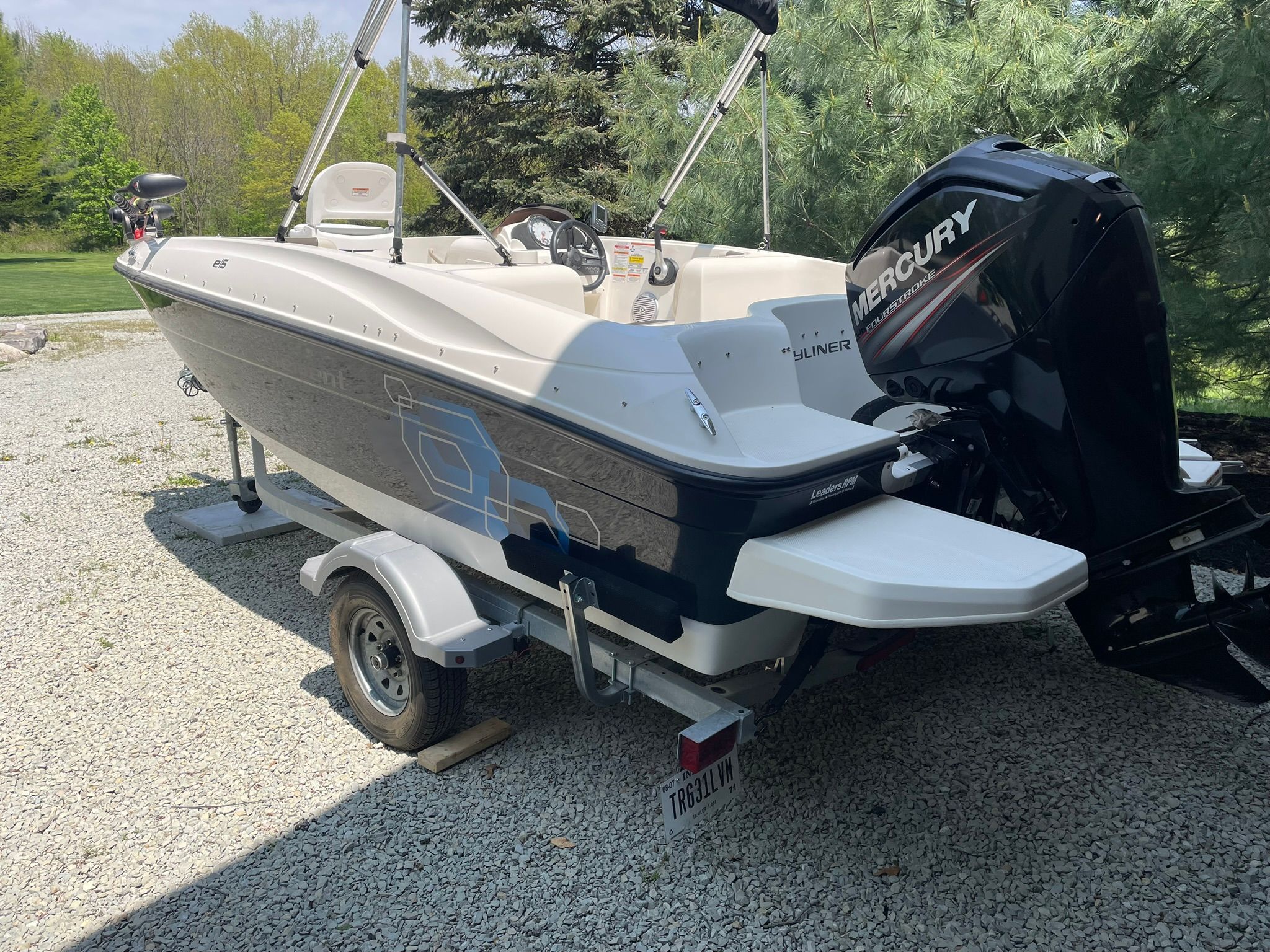 A 2018 Bayliner 160 Bowrider on a trailer, surrounded by trees.