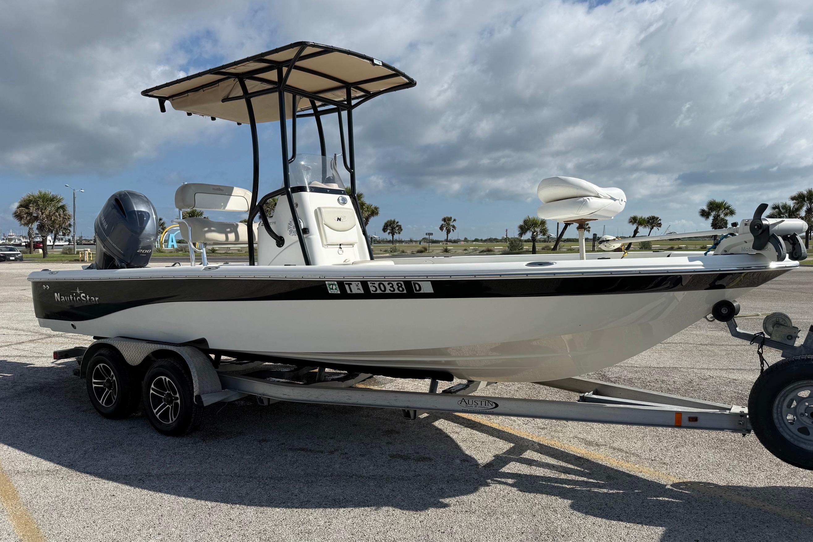 2015 NauticStar 224 XTS boat on trailer under cloudy sky.
