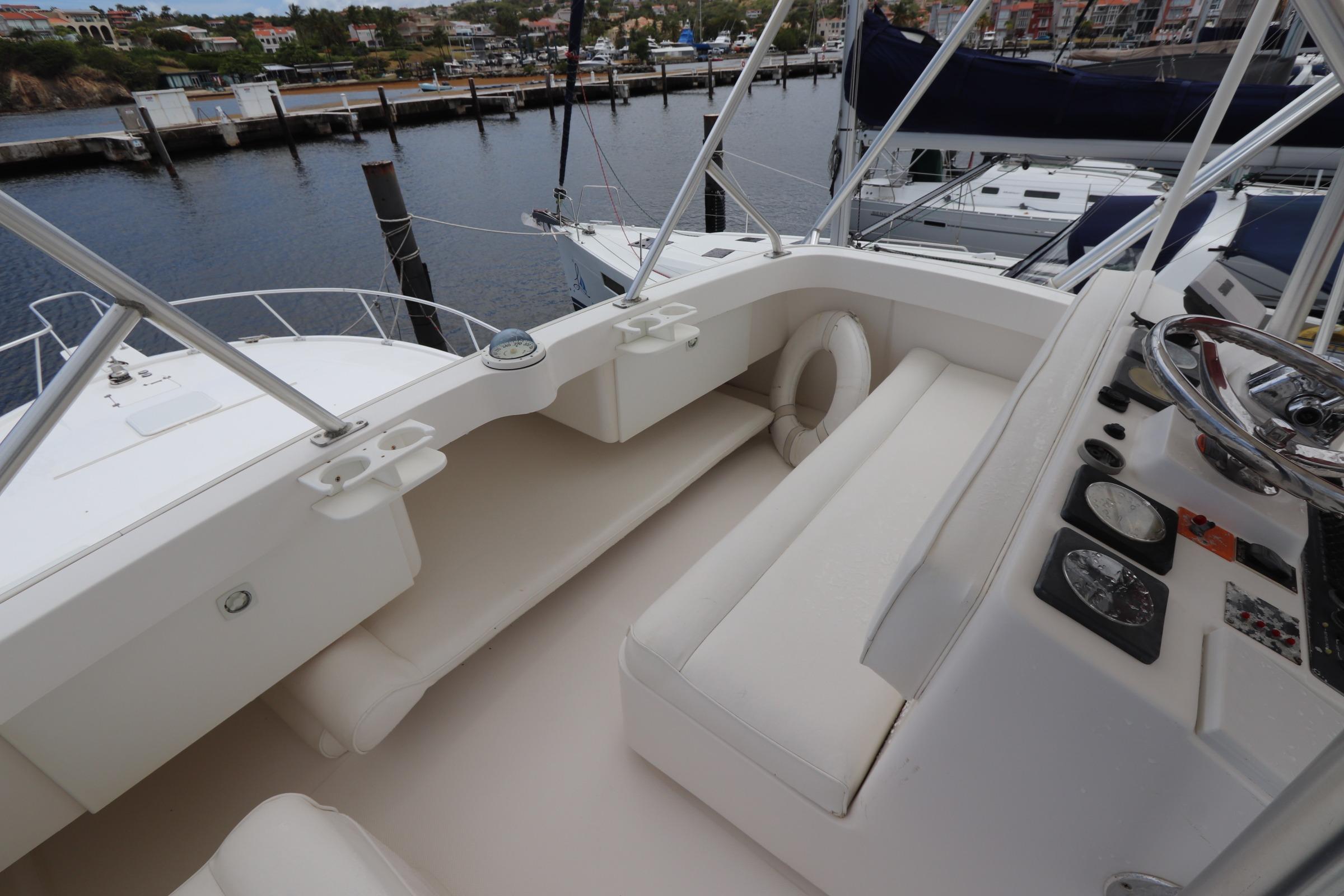 2004 Luhrs 38 Convertible yacht cockpit with seating and steering wheel, docked at marina.