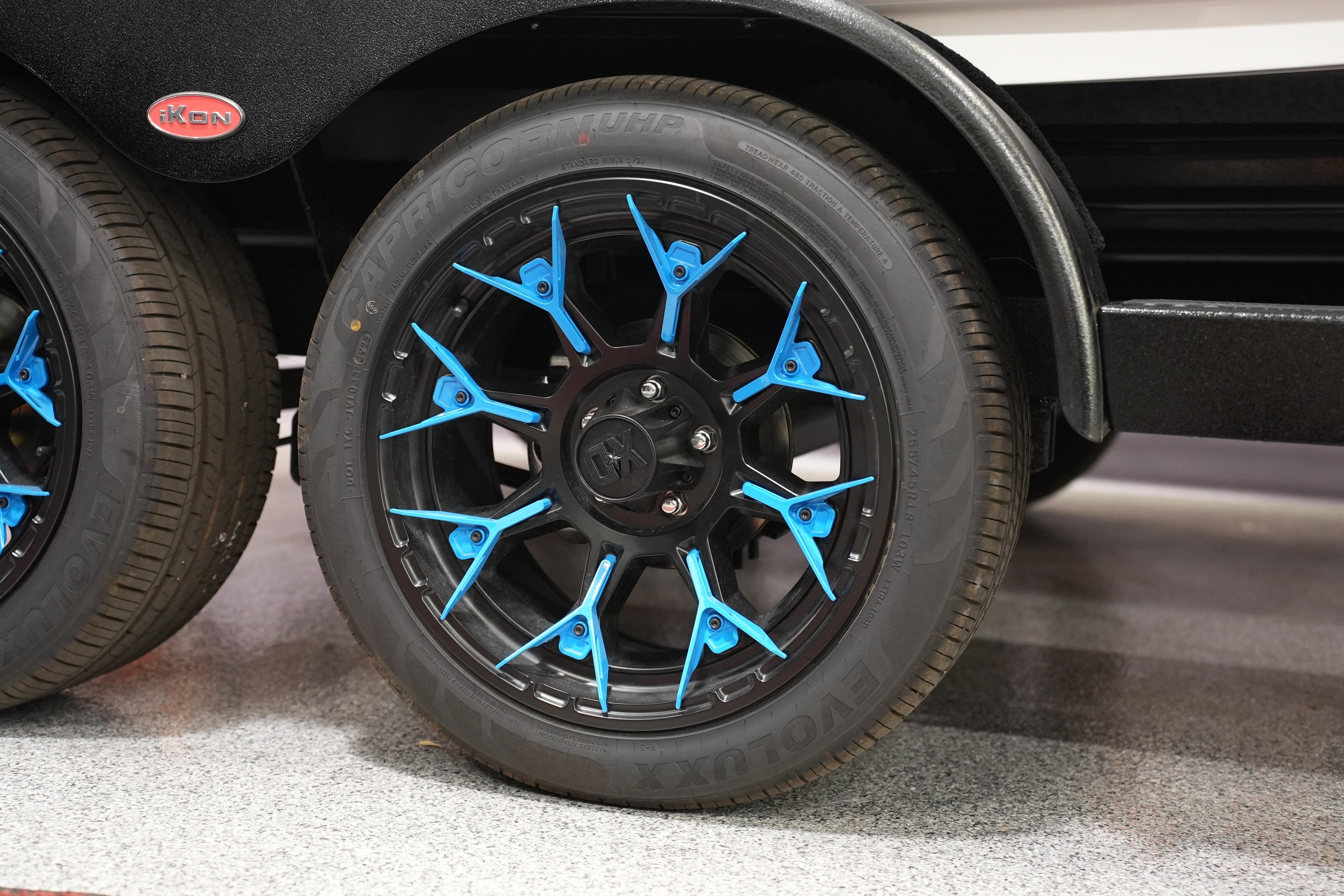 Blue-accented wheel of 2026 iKon VLE21 vehicle on display.