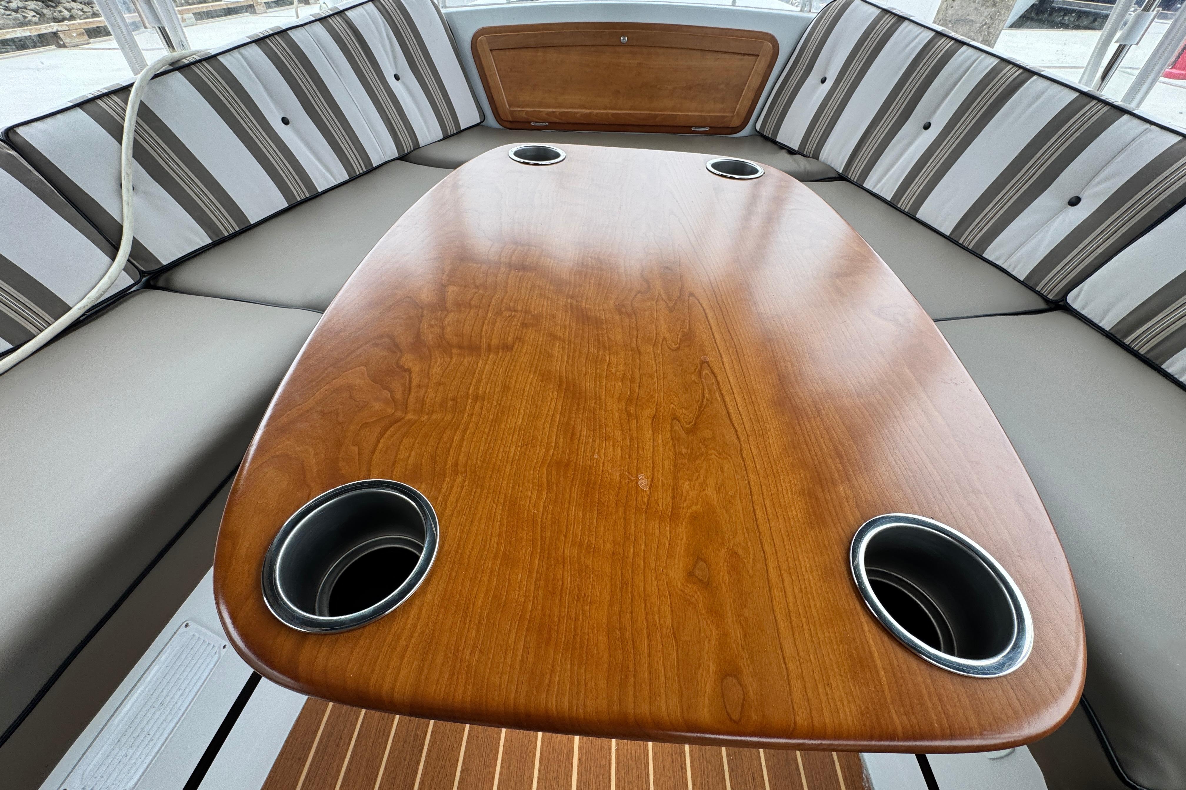 Interior of 2023 Duffy Bay Cruiser with wooden table and striped seating.