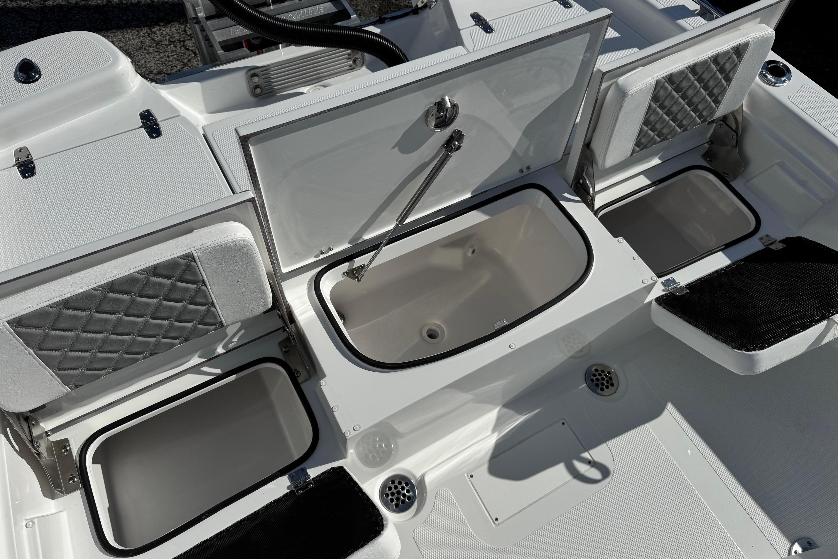 2026 BlackJack 256 Bay boat storage compartments with open lids, showcasing interior design.